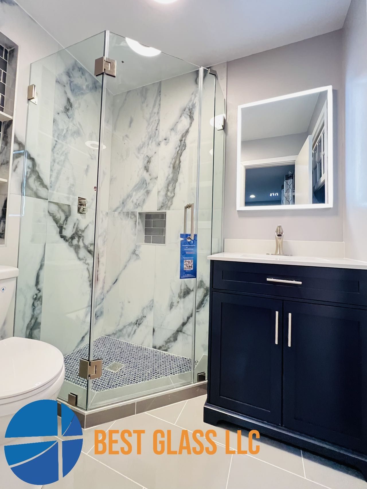 A bathroom with a walk in shower , sink , toilet and mirror.