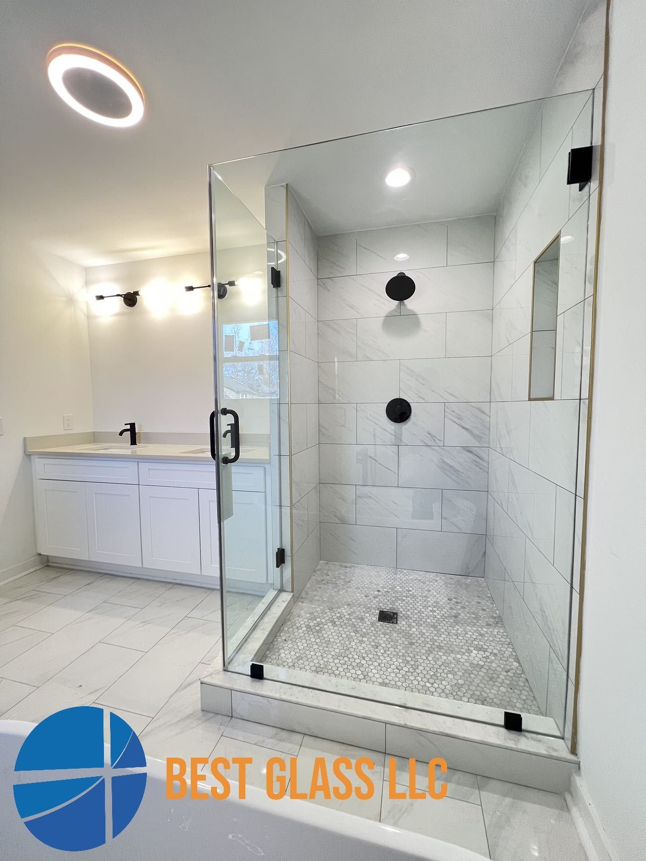 A bathroom with a walk in shower and a sink.