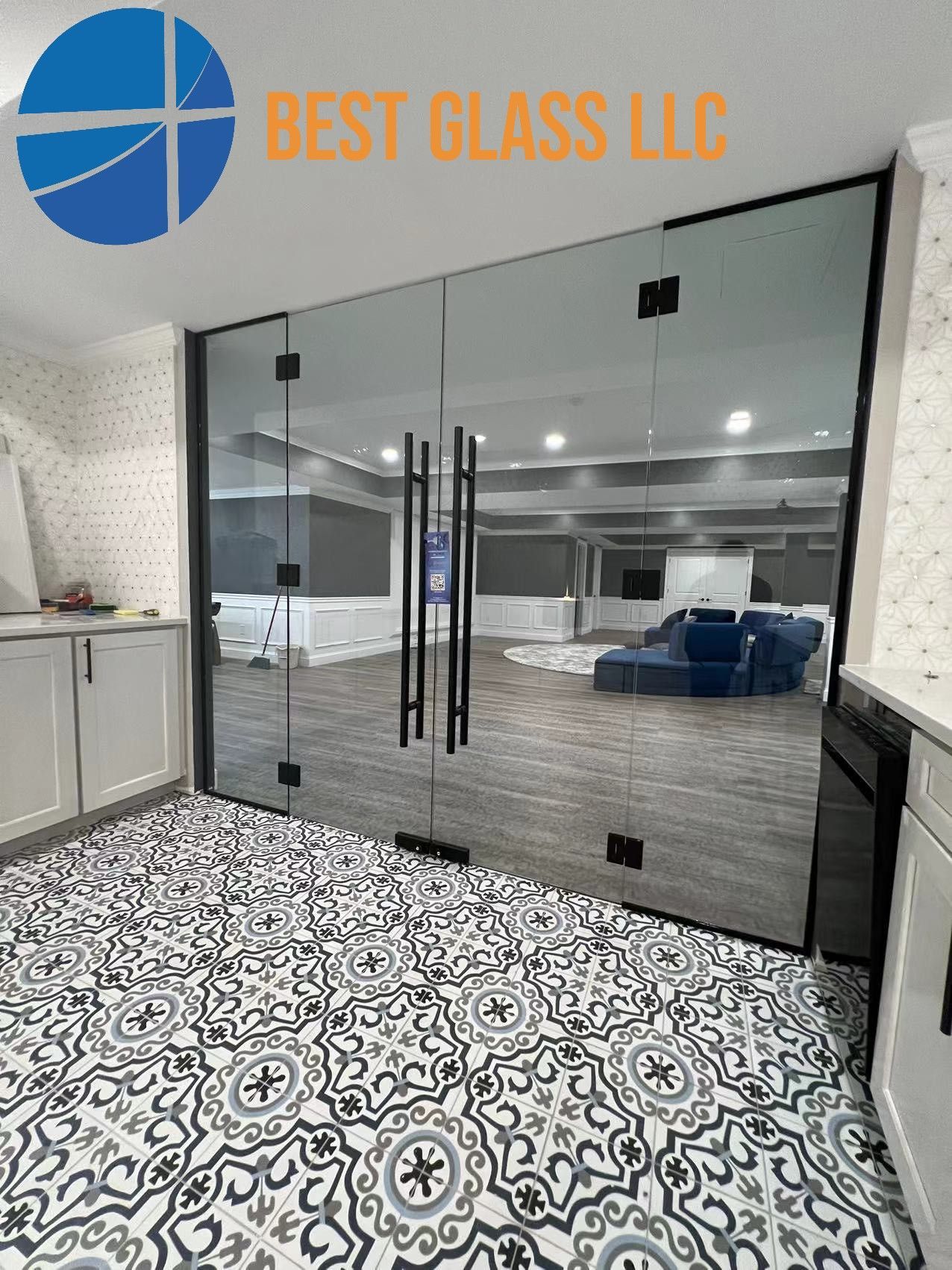 A room with a tiled floor and a glass door between it and a living room.