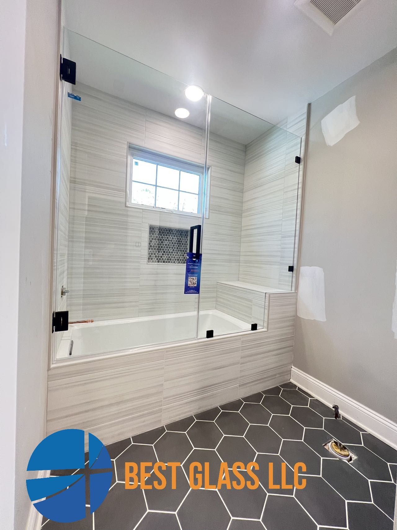 A bathroom with a bathtub and a shower with a glass door.