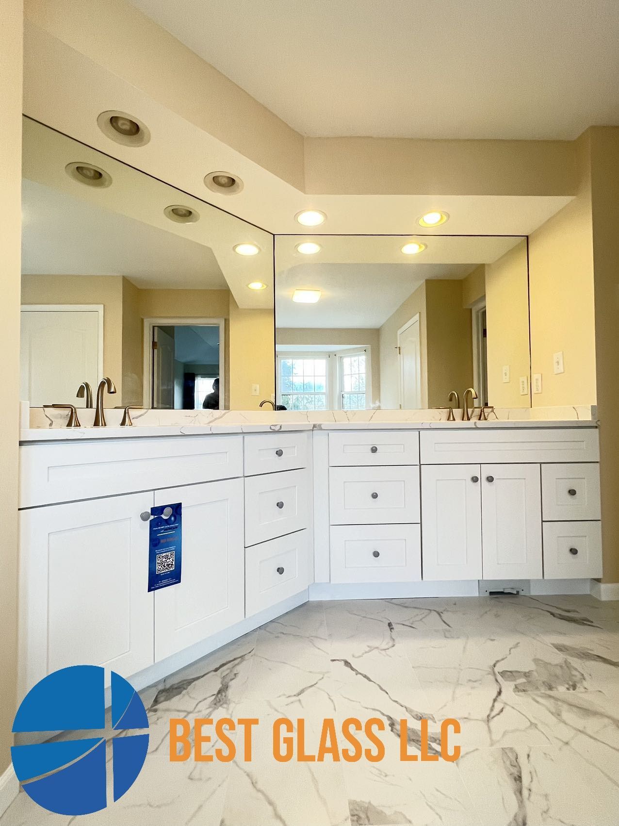 A bathroom with two sinks and a large mirror by best glass llc