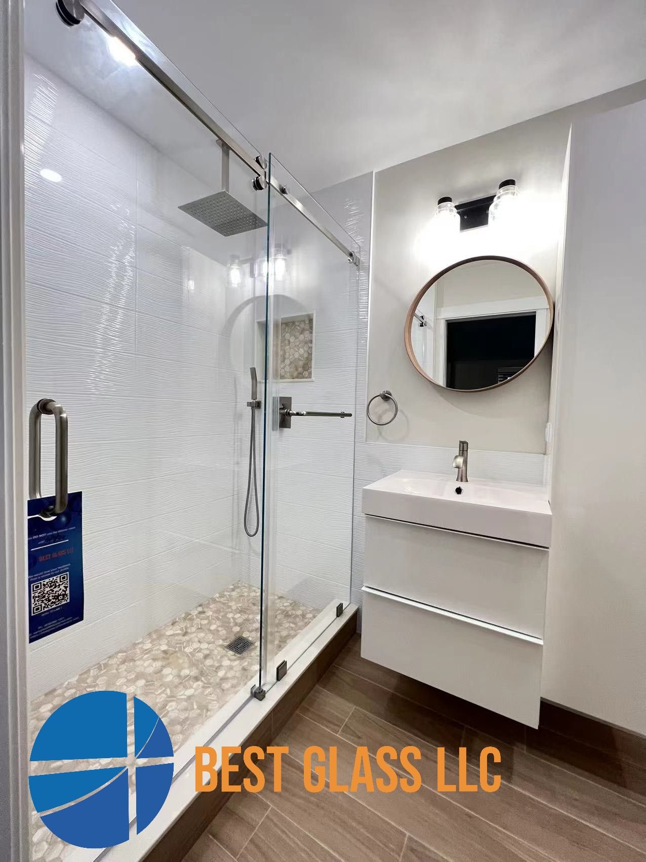 A bathroom with a walk in shower and a sink.