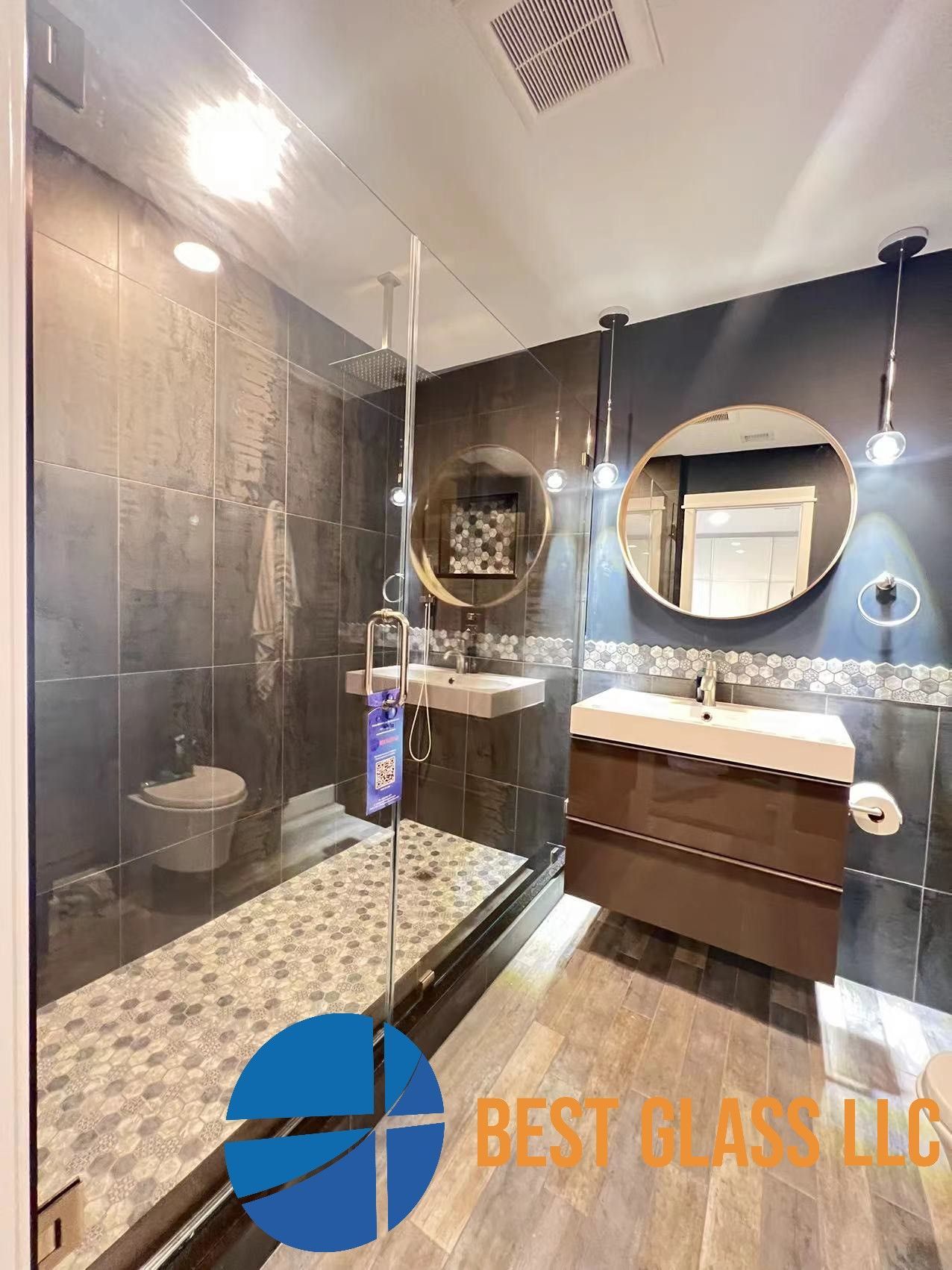 A bathroom with a walk in shower , sink , toilet and mirrors.