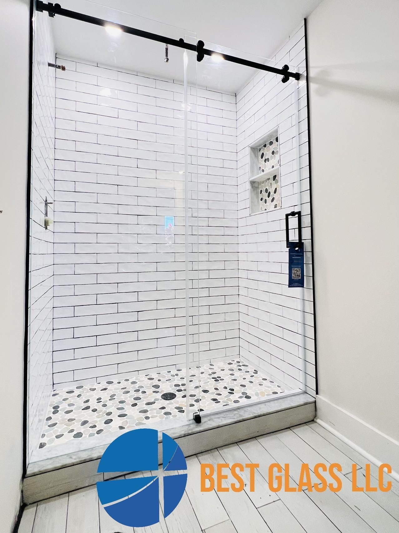 A bathroom with a sliding glass shower door from best glass llc