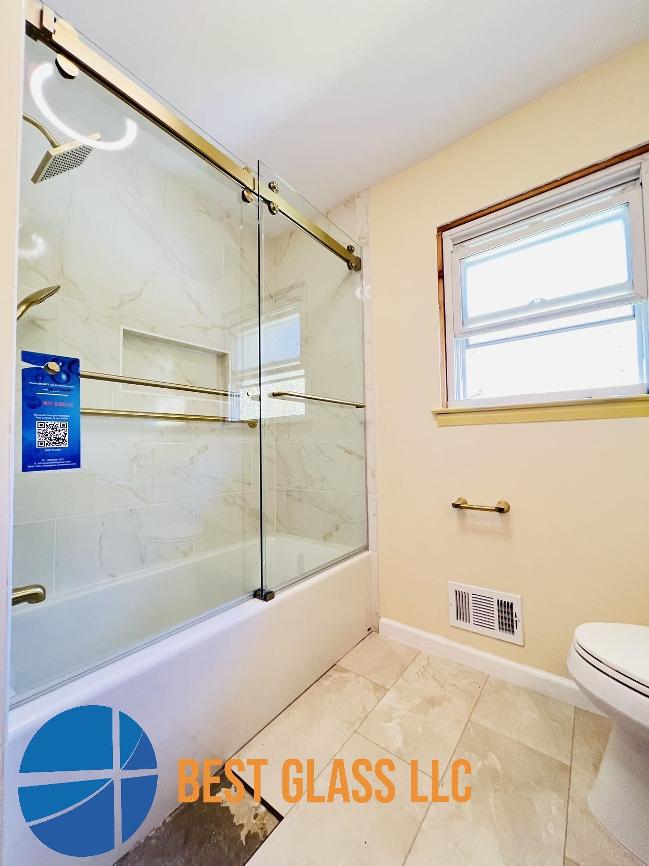 A bathroom with a sliding glass shower door and a toilet.