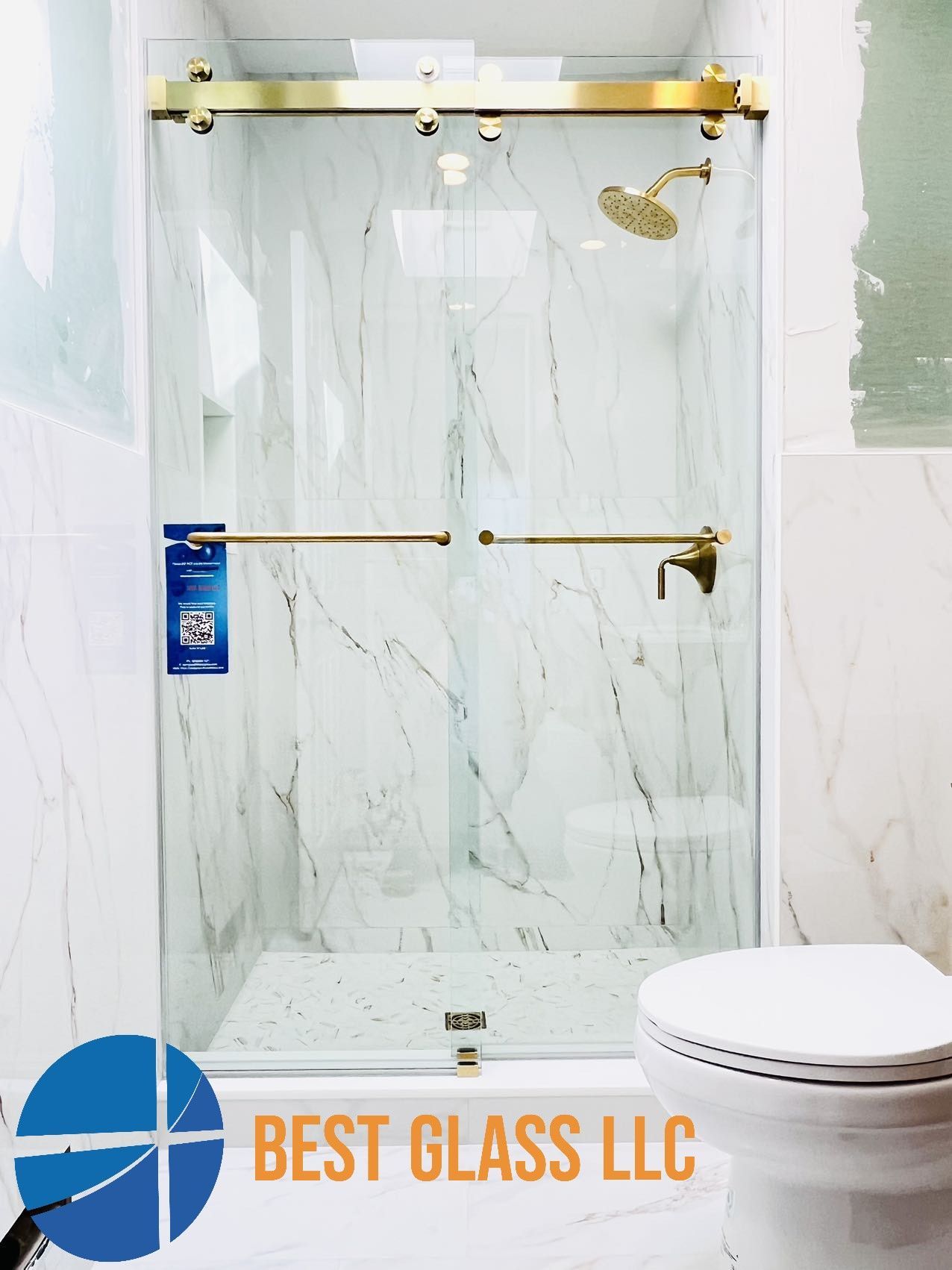 A bathroom with a sliding glass shower door and a toilet