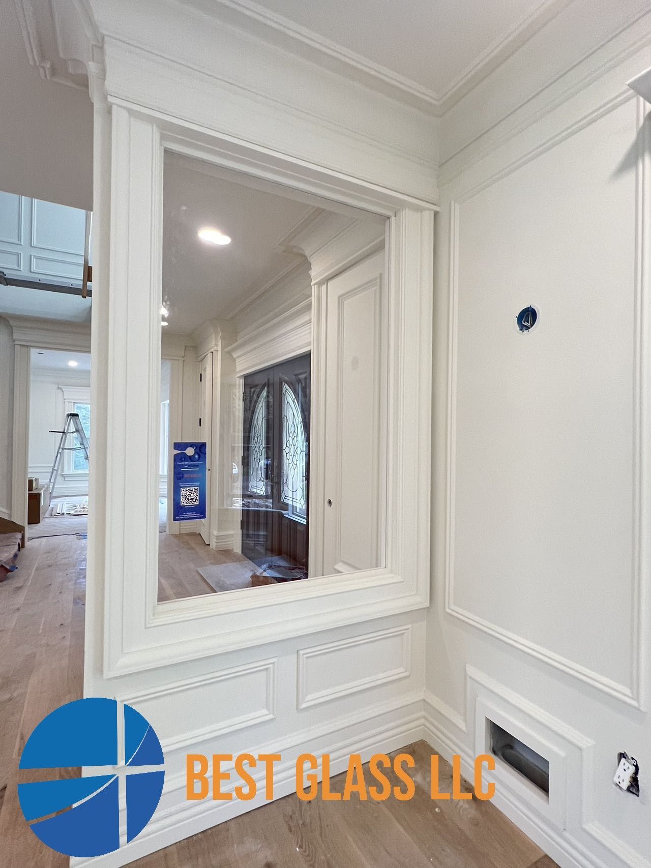 A large mirror is hanging on a wall in a hallway.