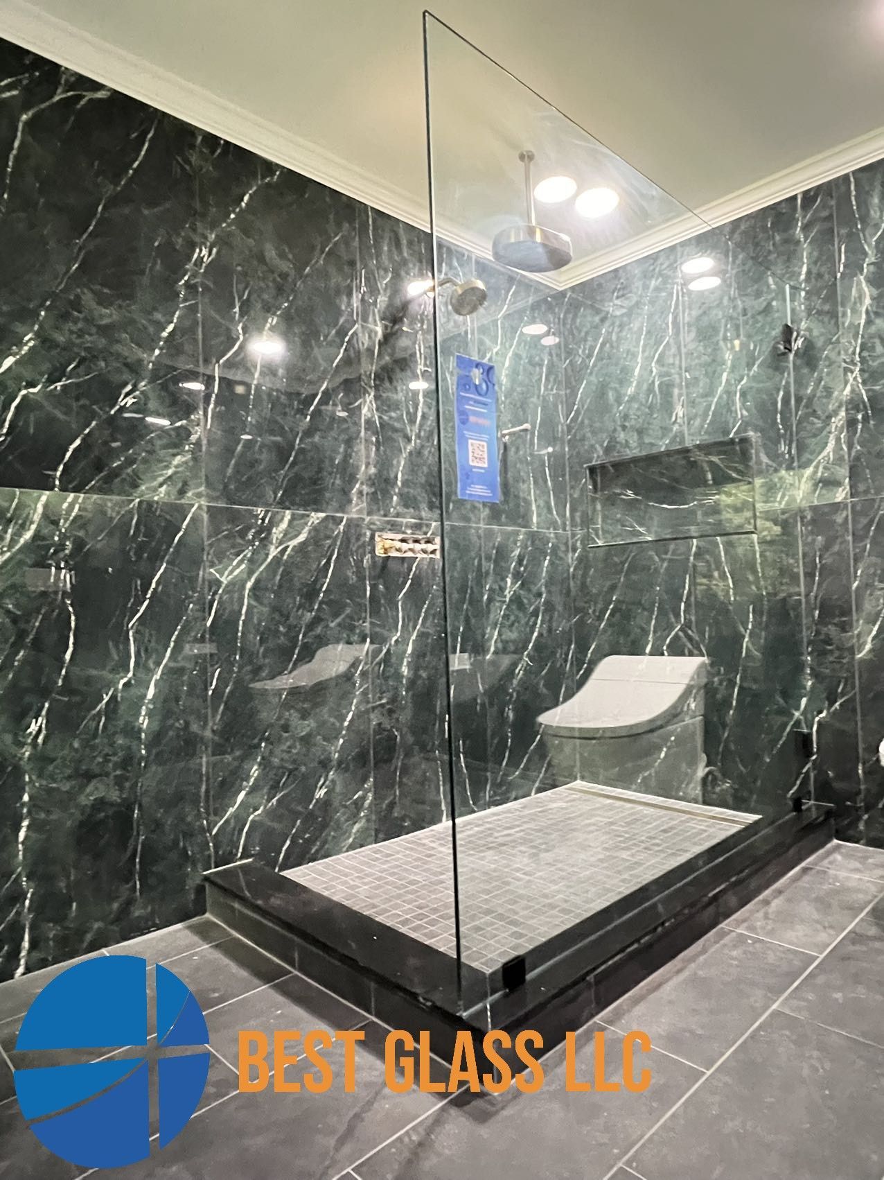 A bathroom with marble walls and a walk in shower.