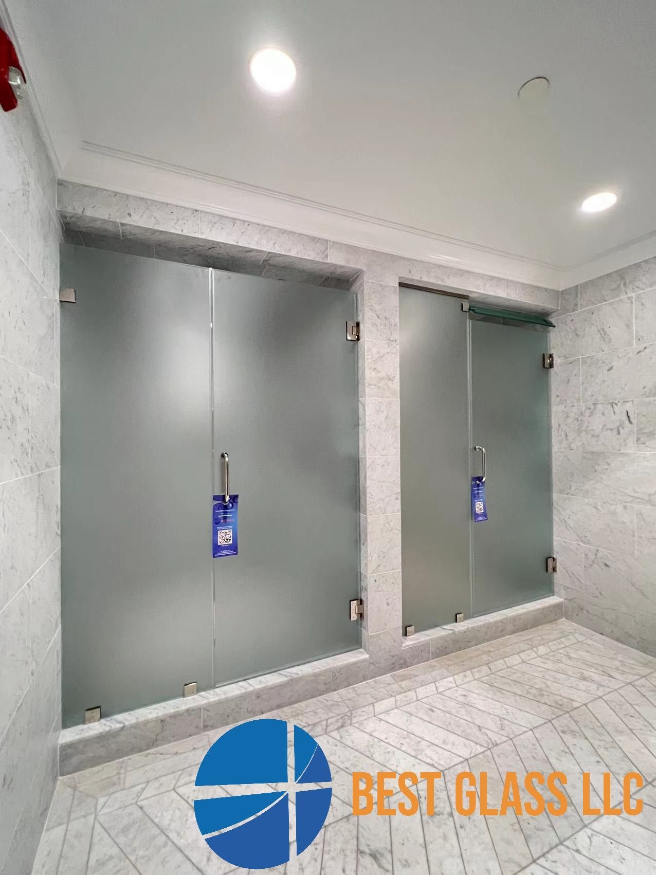 A bathroom with two frosted glass shower doors.