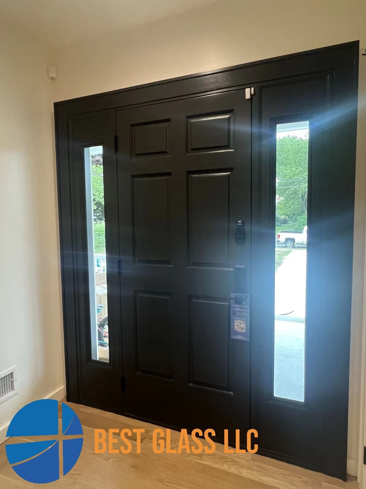 A black door with two windows in a hallway.