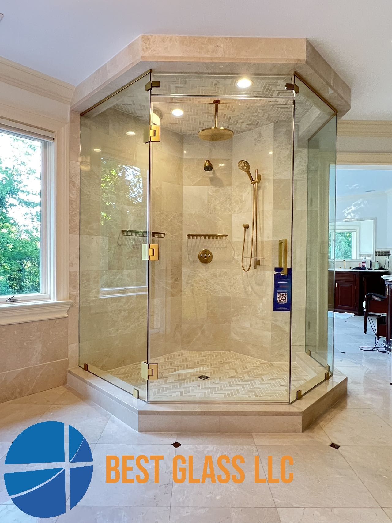 A bathroom with a walk in shower and a sign that says best glass llc