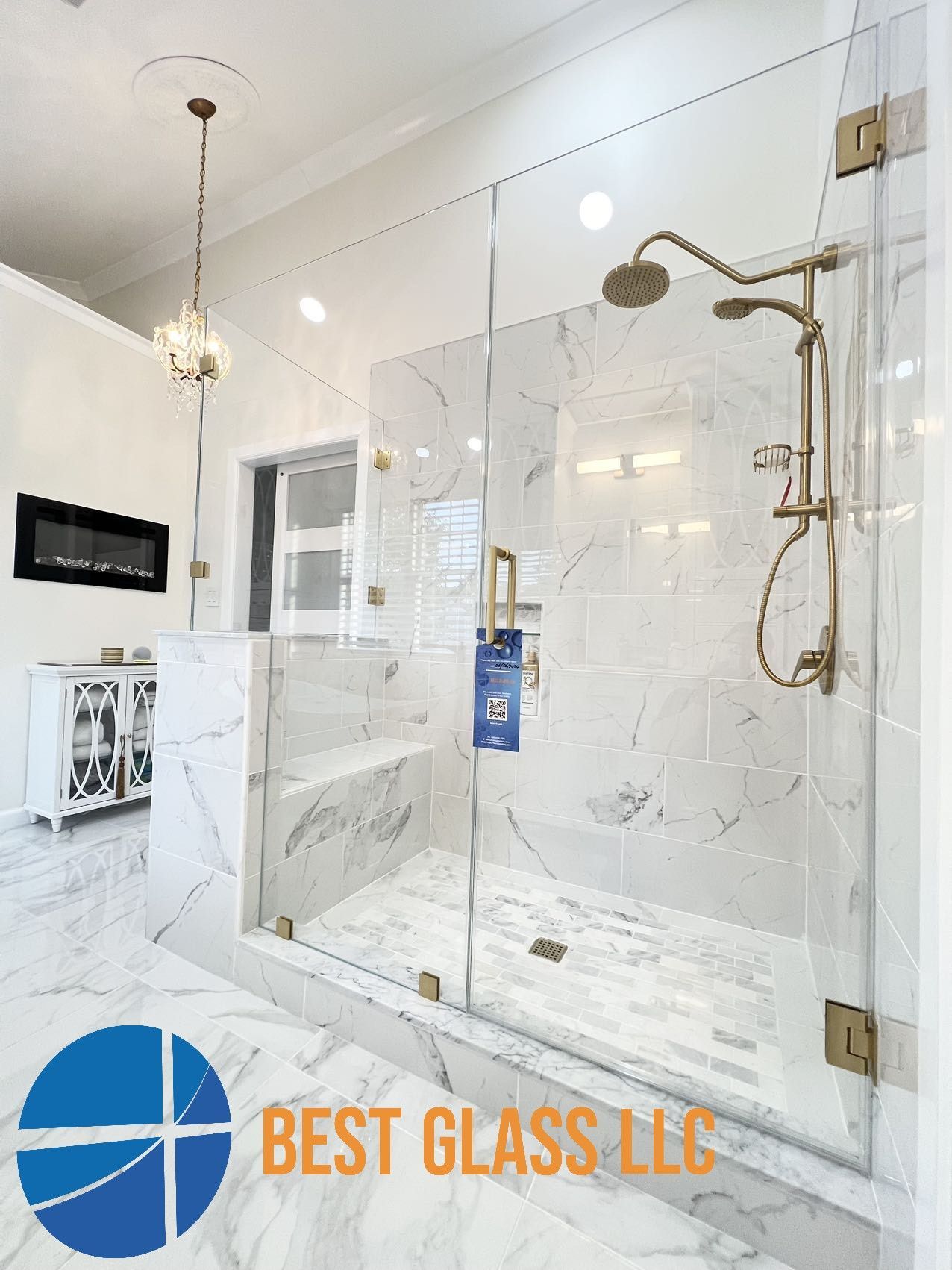 A bathroom with a walk in shower with a glass door.