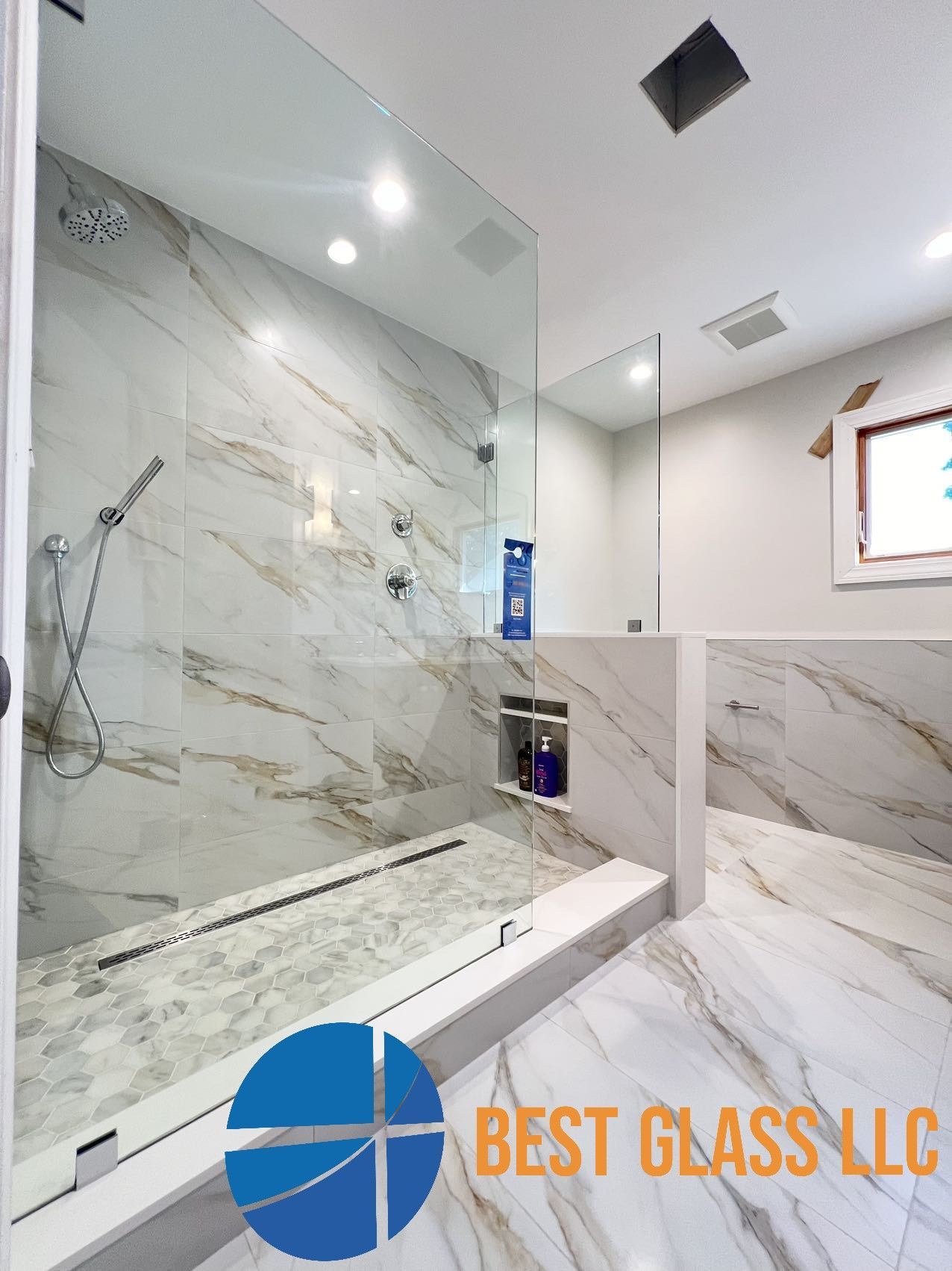A bathroom with a walk in shower and a marble floor.