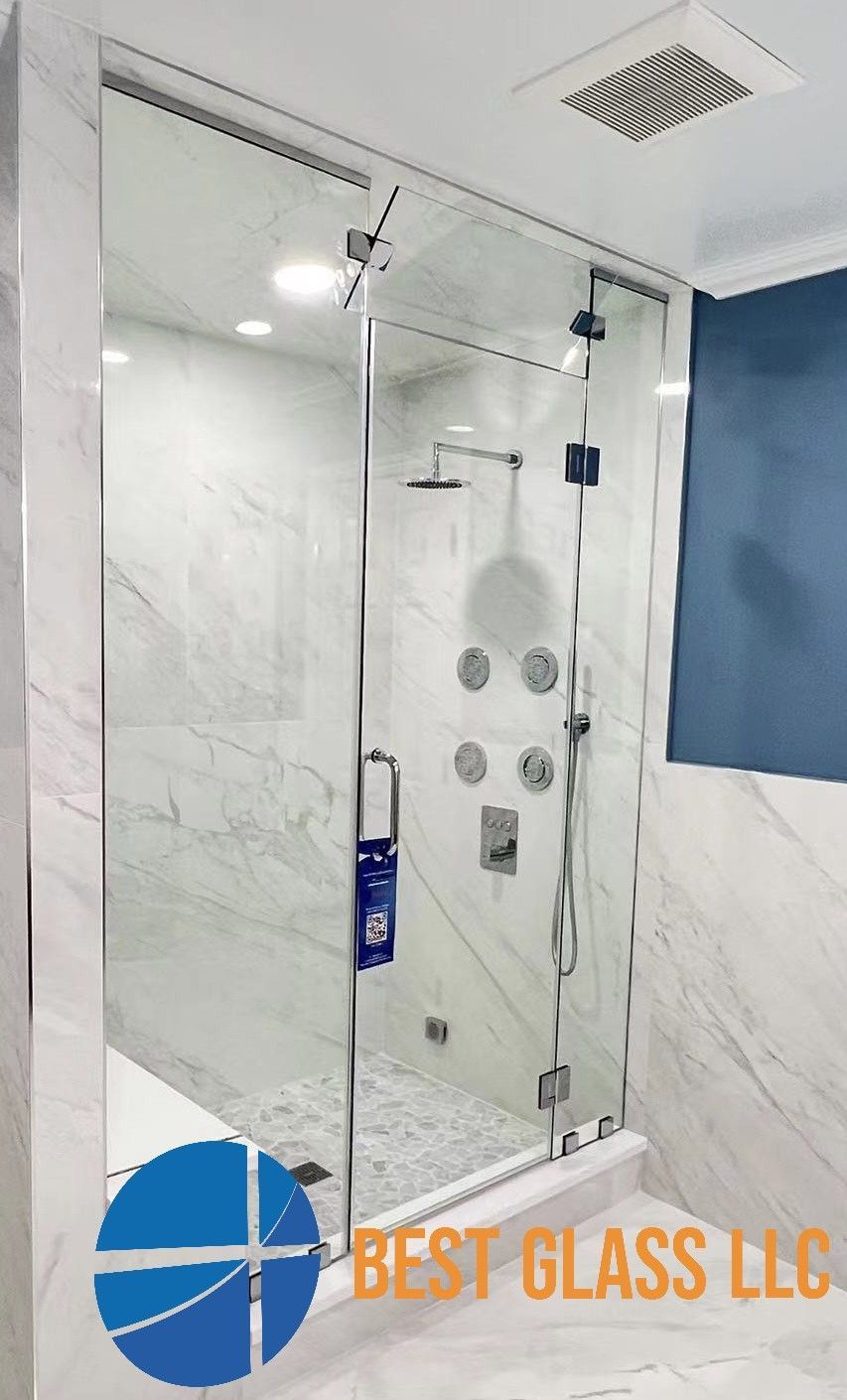 A bathroom with a glass shower door and a blue wall.