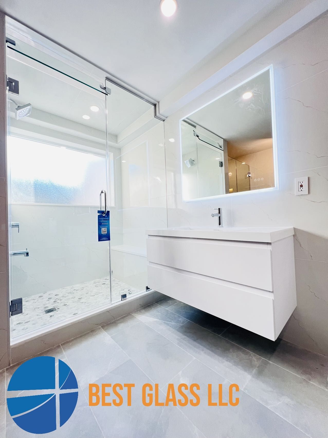 A bathroom with a sink , shower and mirror.
