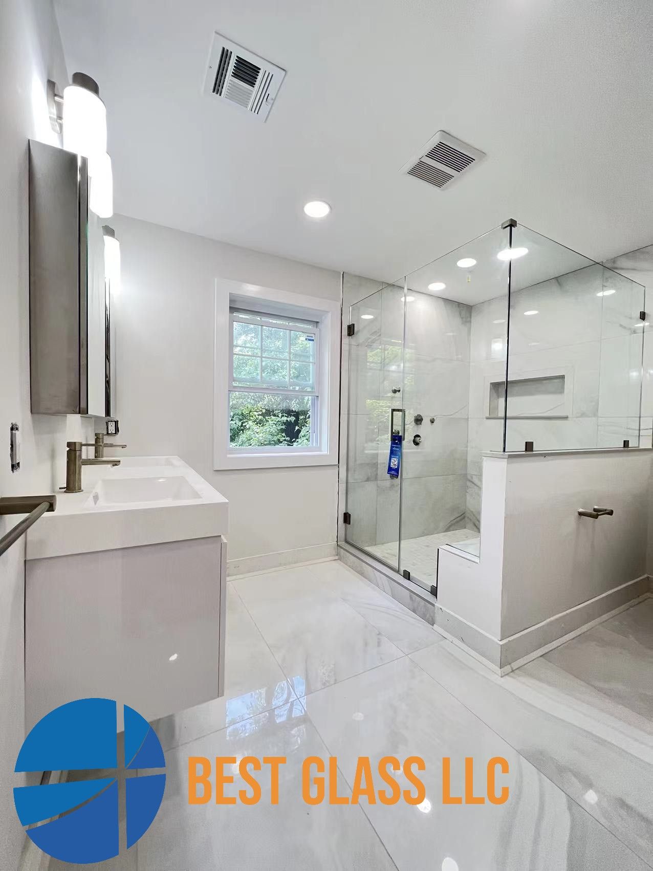 A bathroom with a walk in shower and a sink.