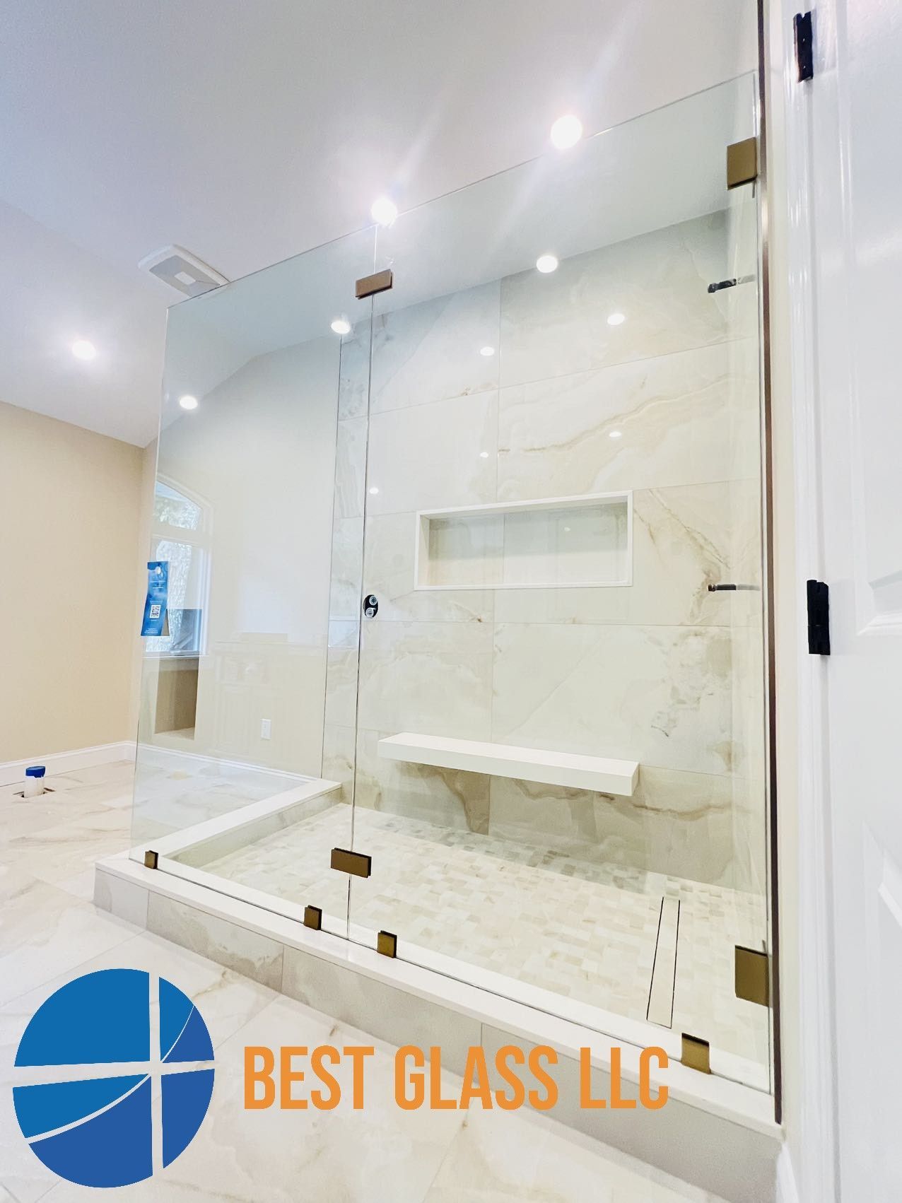 A bathroom with a walk in shower and a bench.