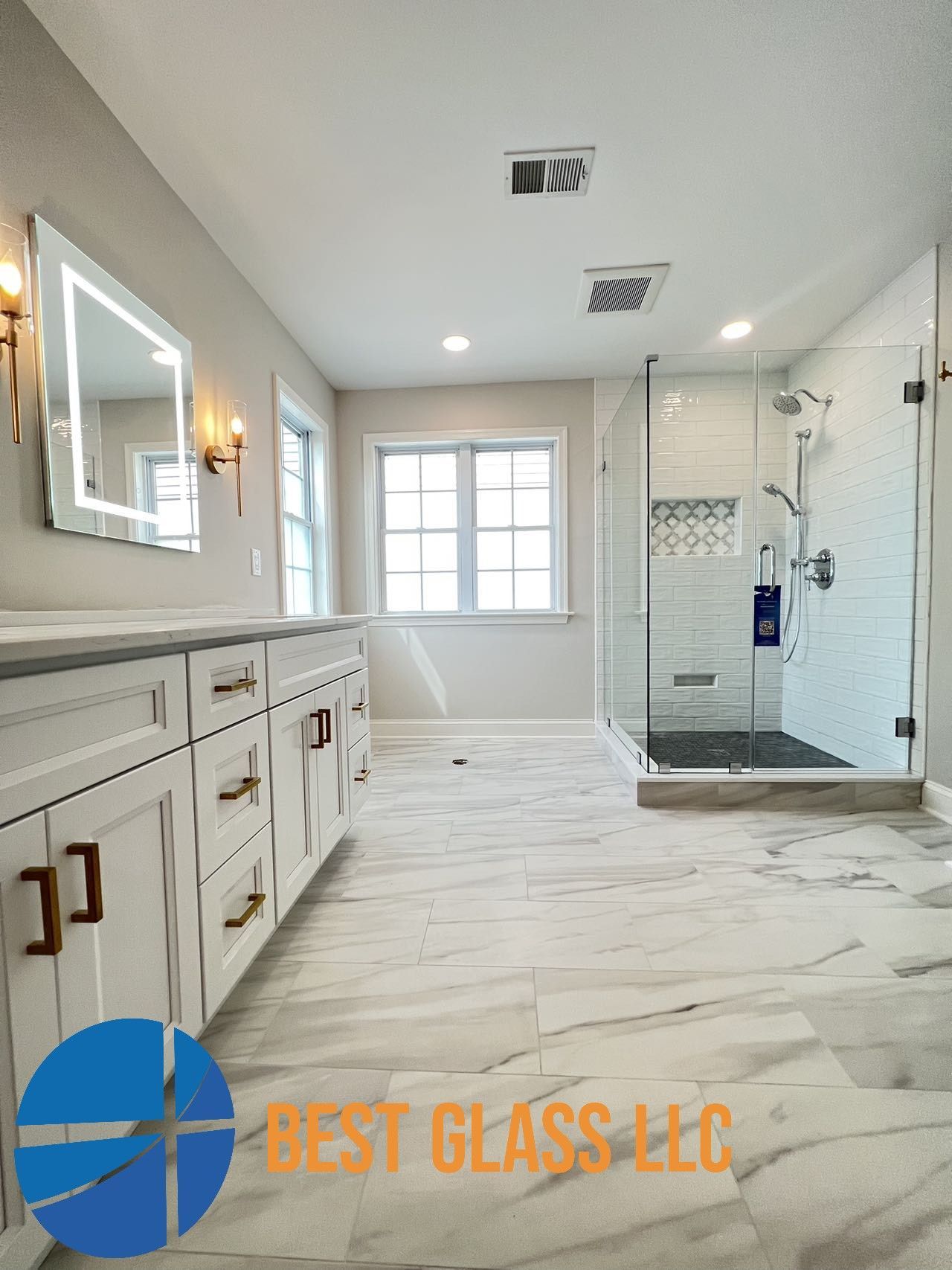 A bathroom with two sinks and a walk in shower.