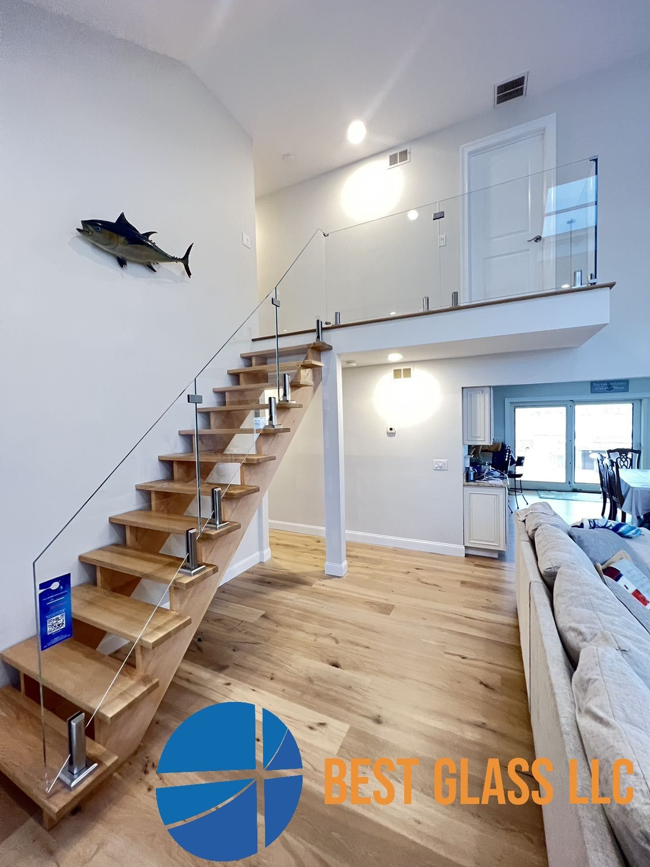A wooden staircase with a glass railing in a living room.