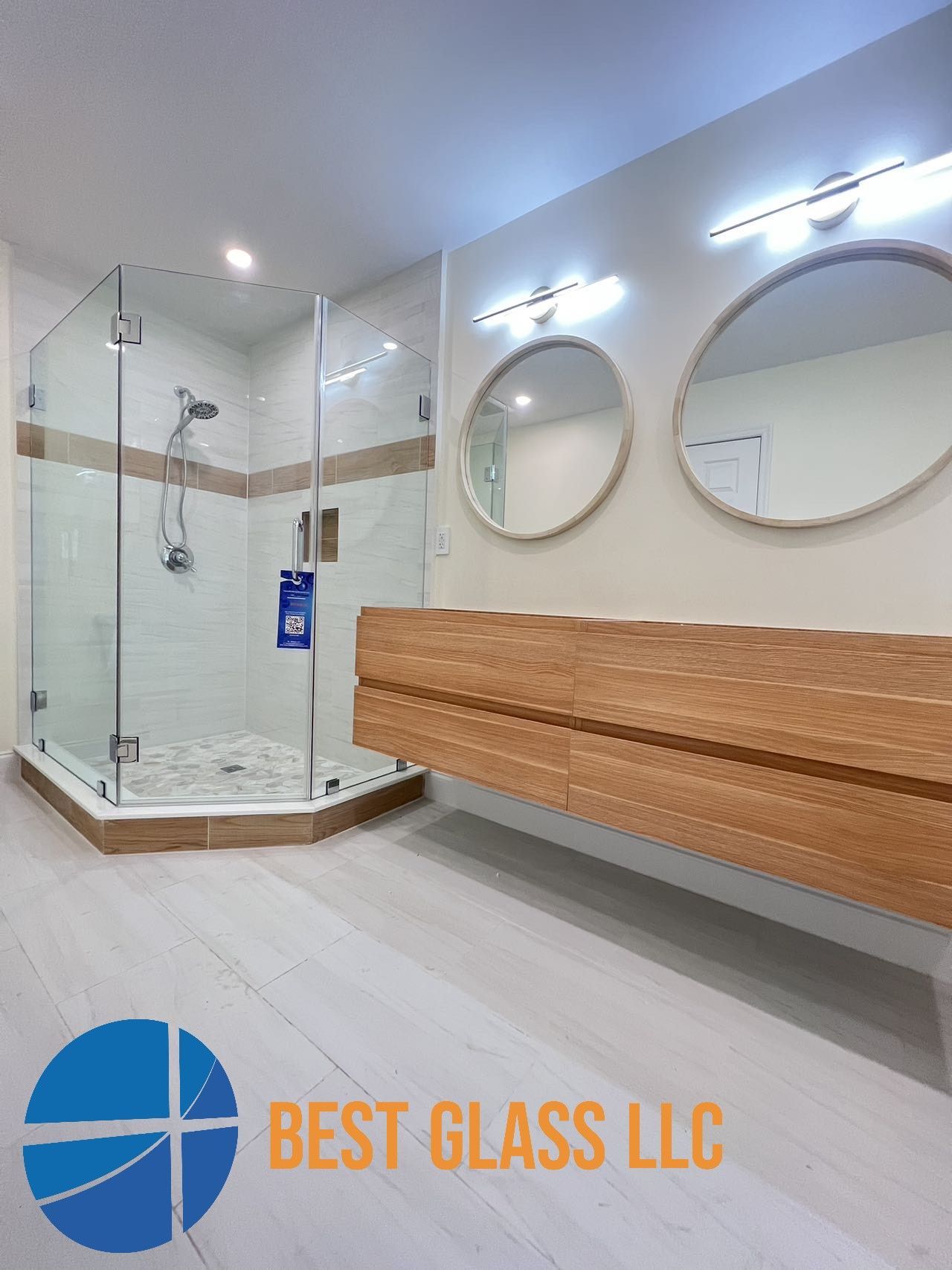 A bathroom with a walk in shower and two mirrors.