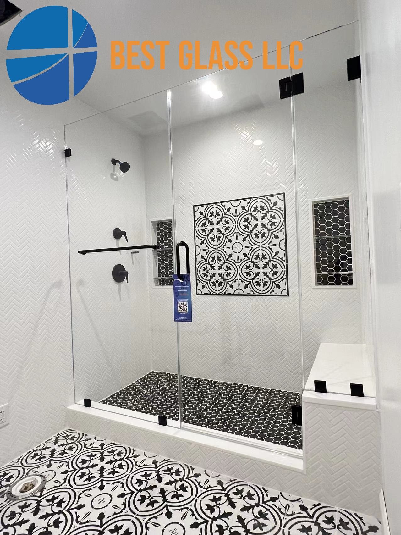 A bathroom with a walk in shower with a black and white tile floor.
