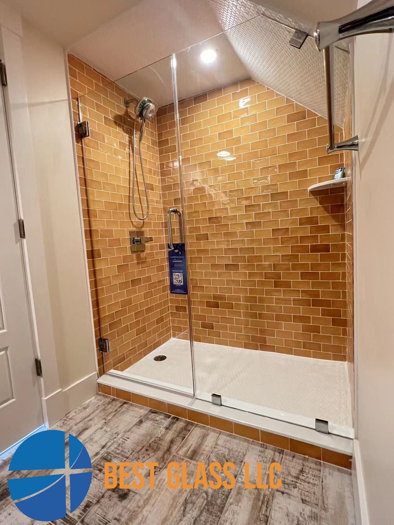 A bathroom with a walk in shower and a brick wall.