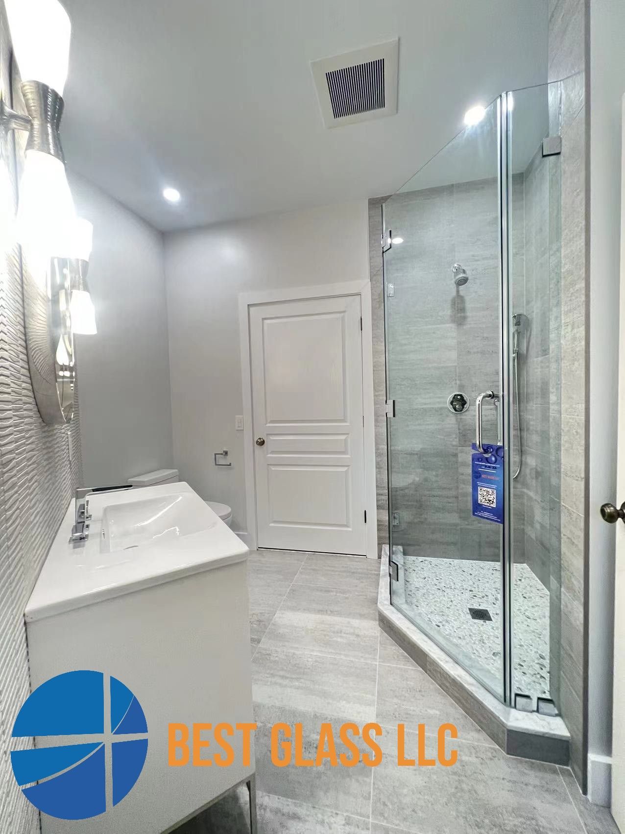 A bathroom with a sink and a walk in shower.