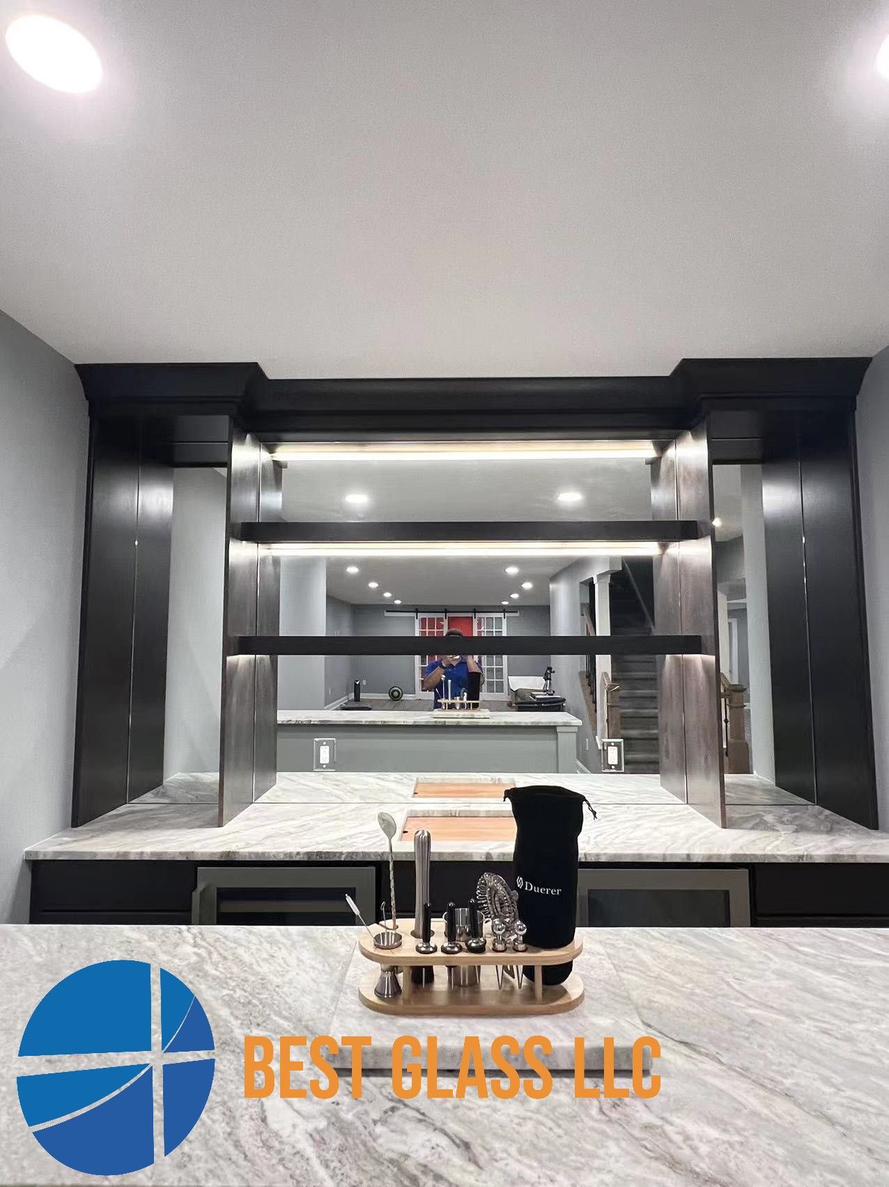 A kitchen with a large mirror on the wall and a marble counter top.