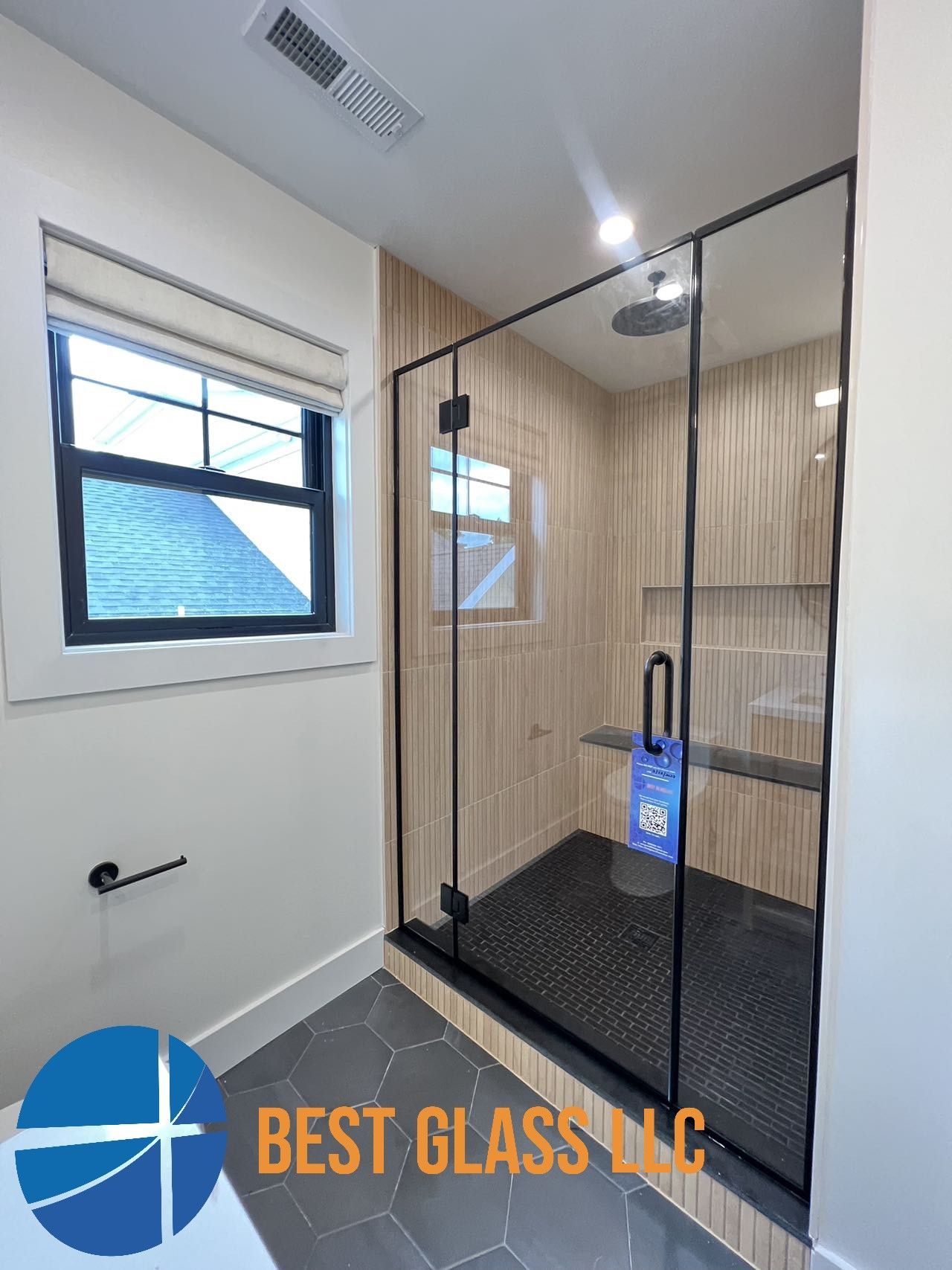A bathroom with a walk in shower and a window.