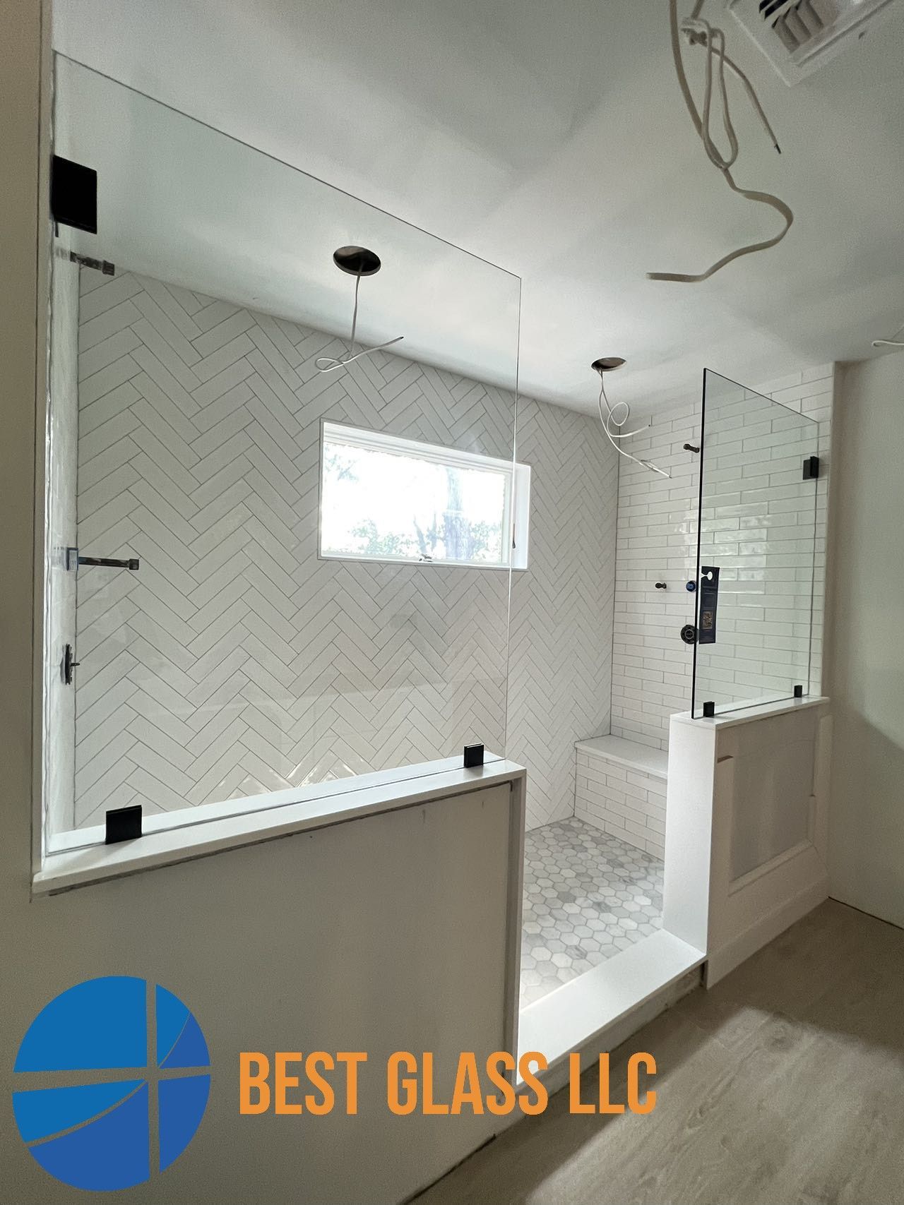 A bathroom with a walk in shower and a window.