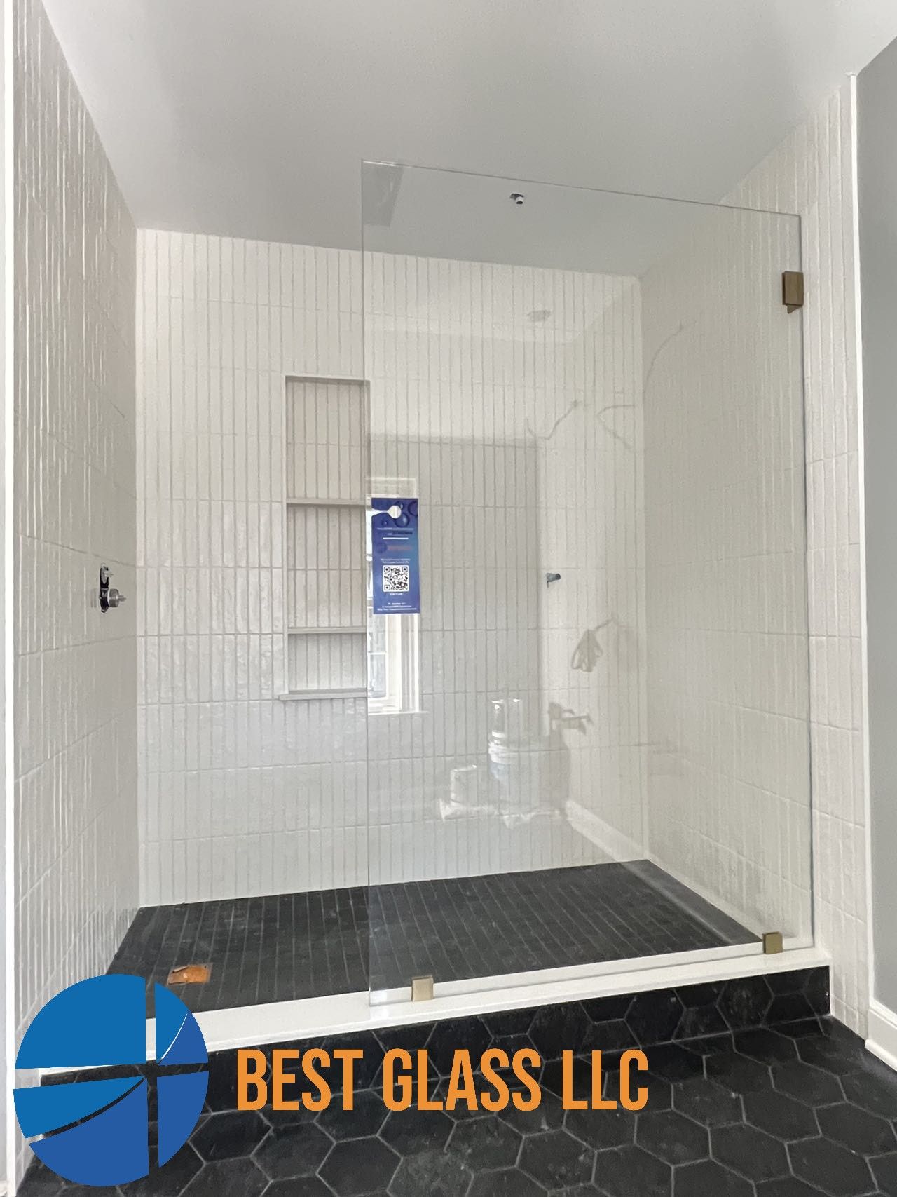 A bathroom with a walk in shower with a glass door.
