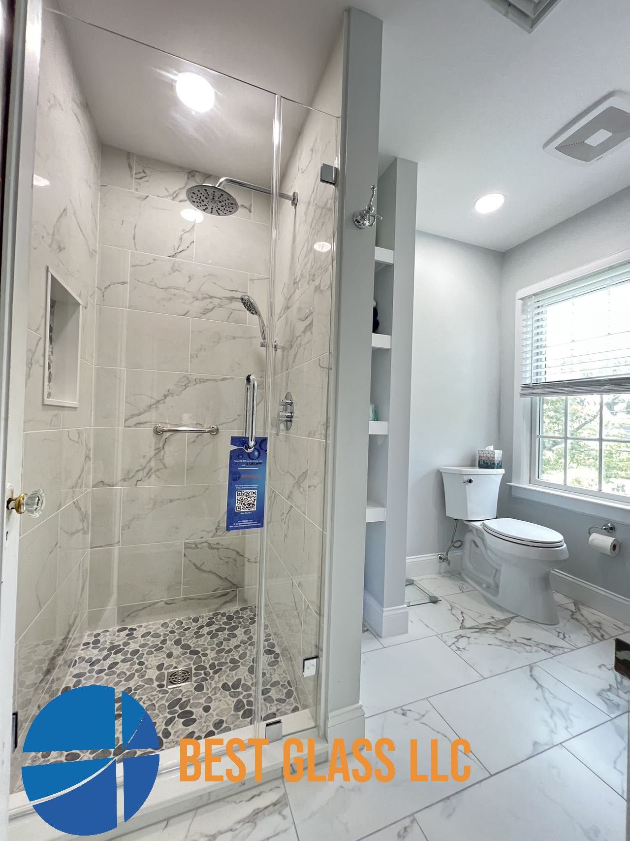 A bathroom with a walk in shower , toilet and window.