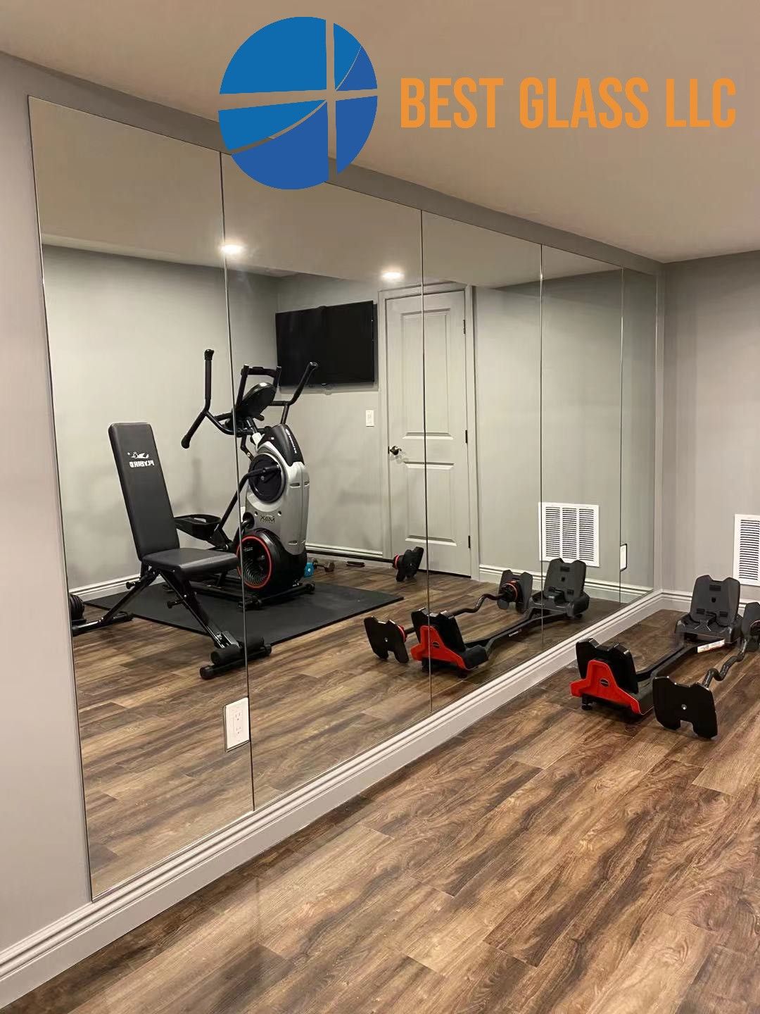 A basement gym with a large mirror and exercise equipment.