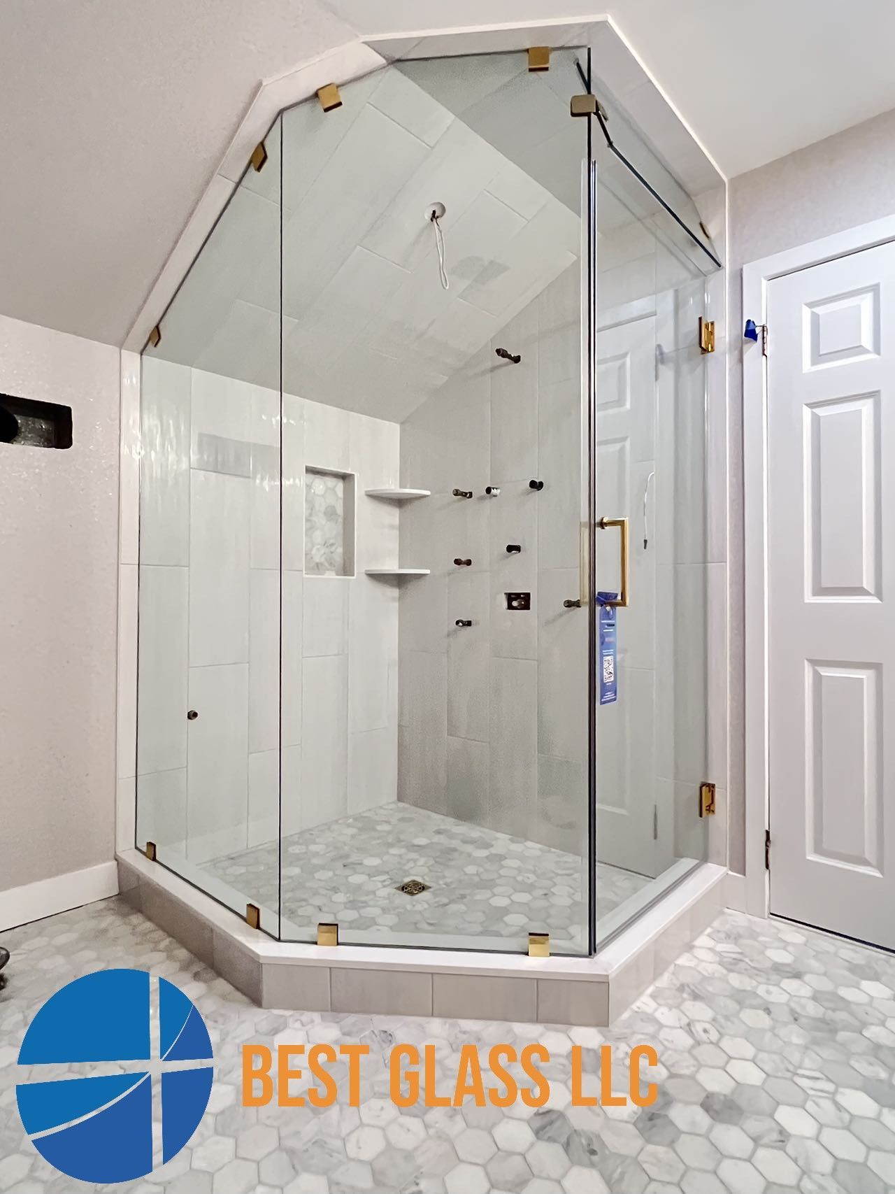 A bathroom with a shower stall and a sign that says best glass llc