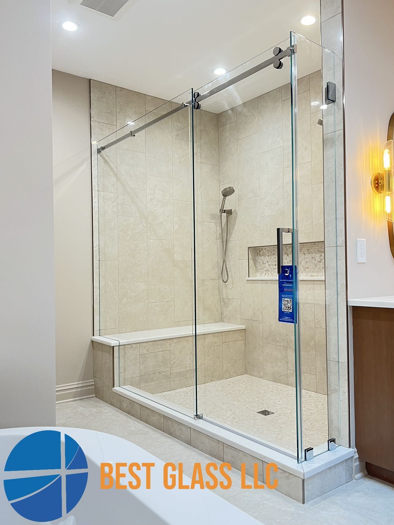 A bathroom with a sliding glass shower door and a bathtub.