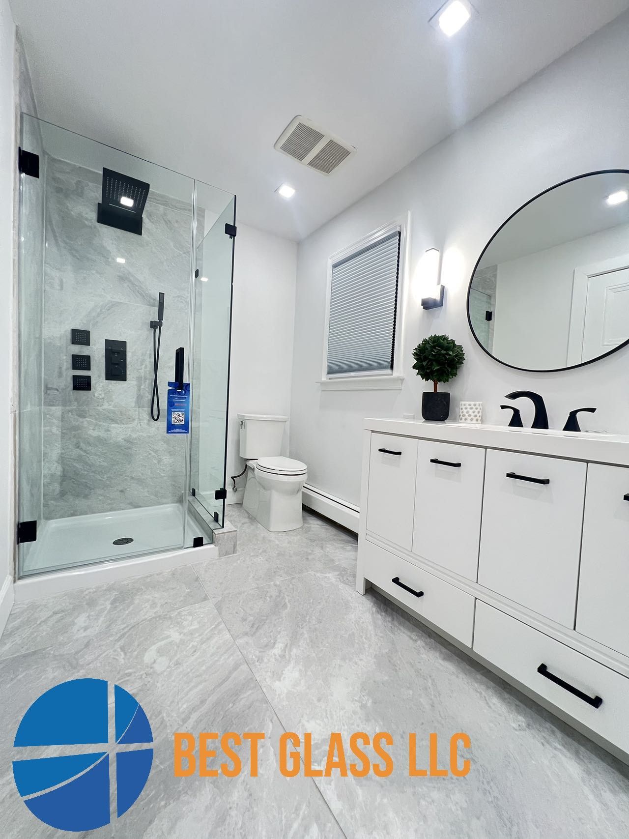 A bathroom with a walk in shower , toilet , sink and mirror.