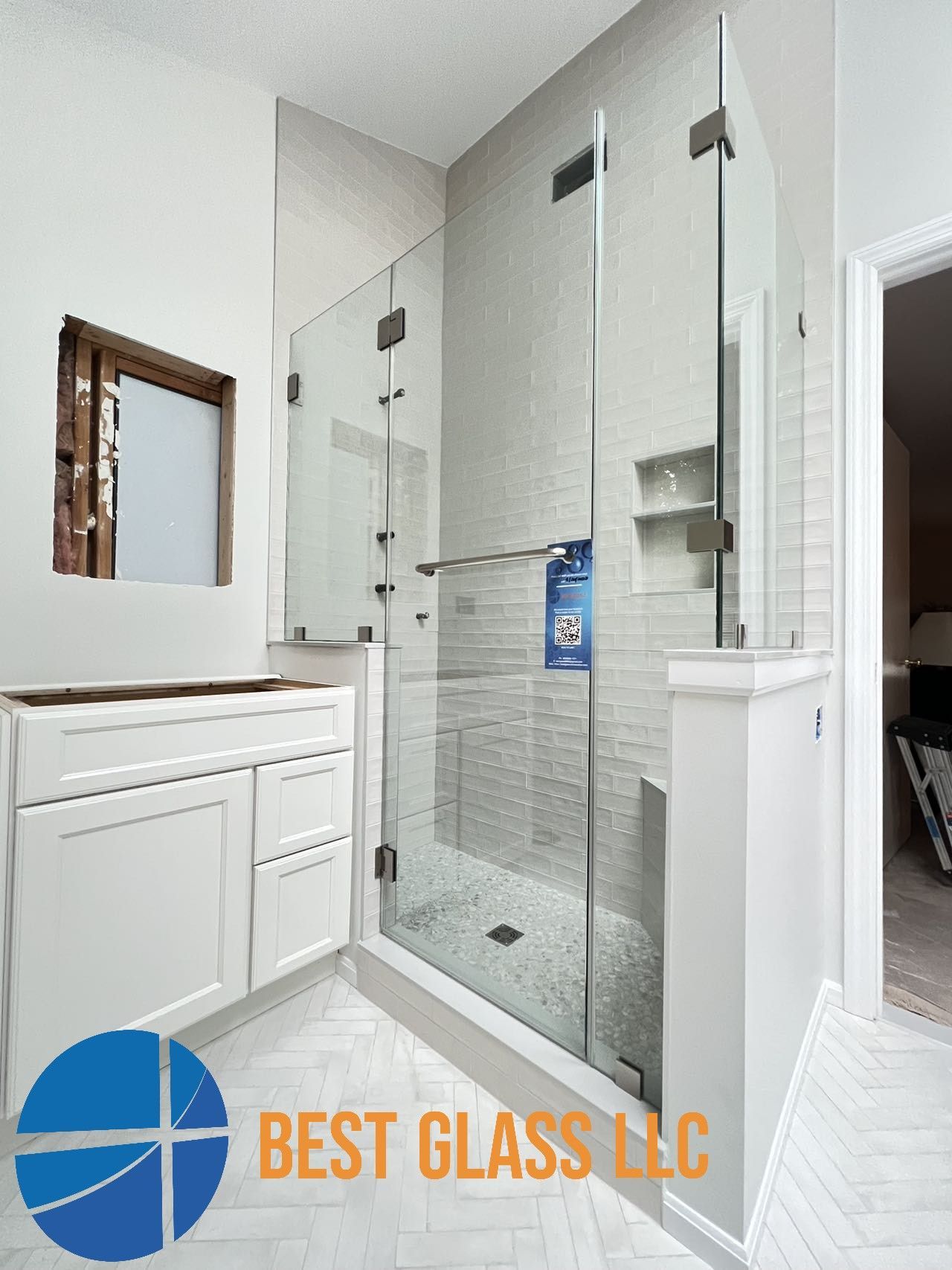 A bathroom with a walk in shower and a sink.