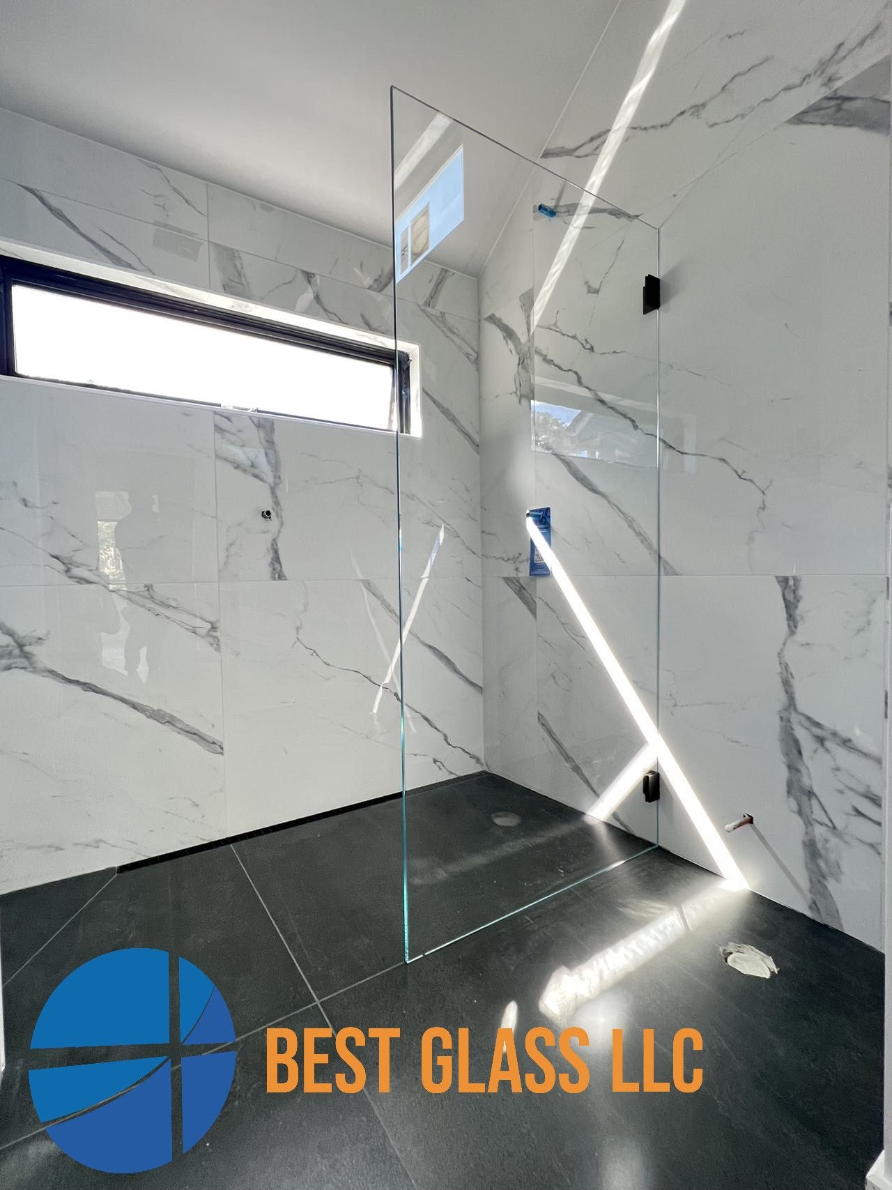 A bathroom with marble walls and a walk in shower.