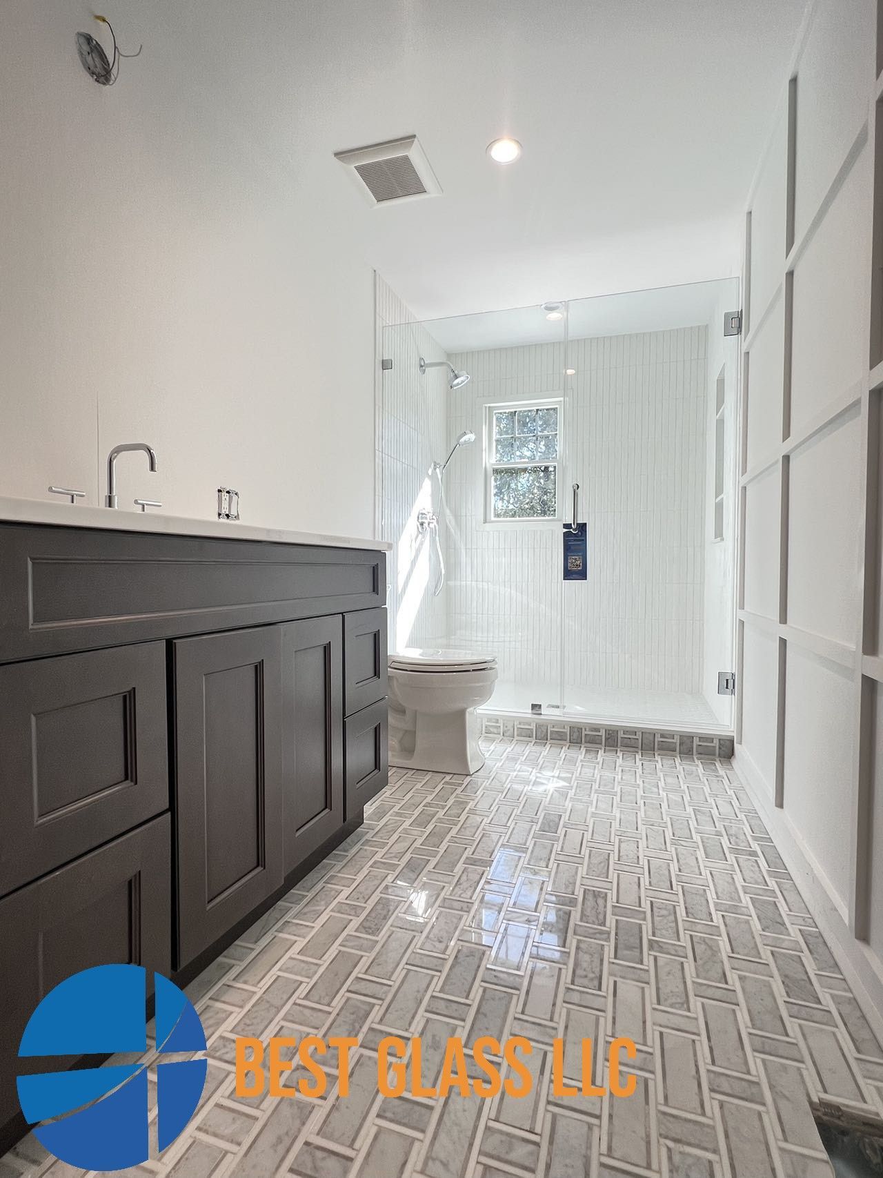 A bathroom with a walk in shower and a sink