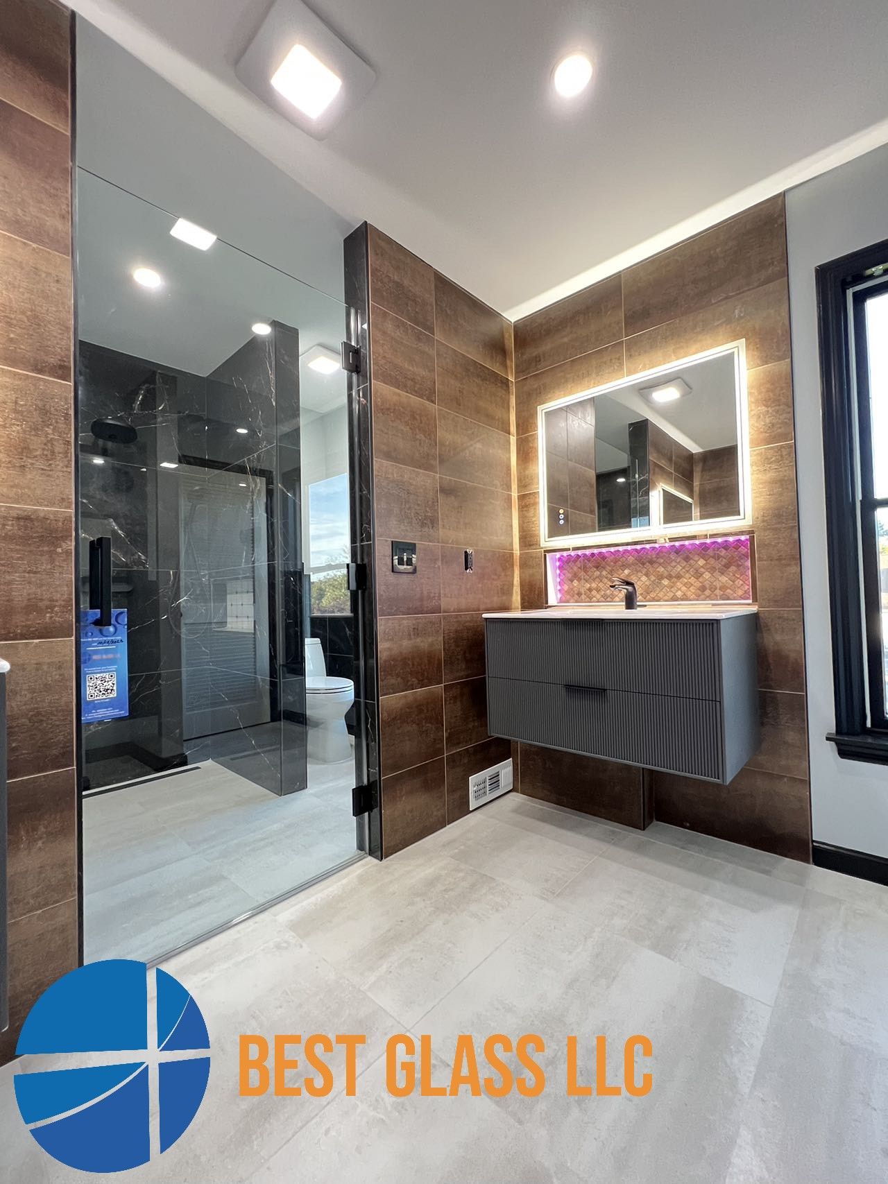 A bathroom with a sink , mirror and walk in shower.
