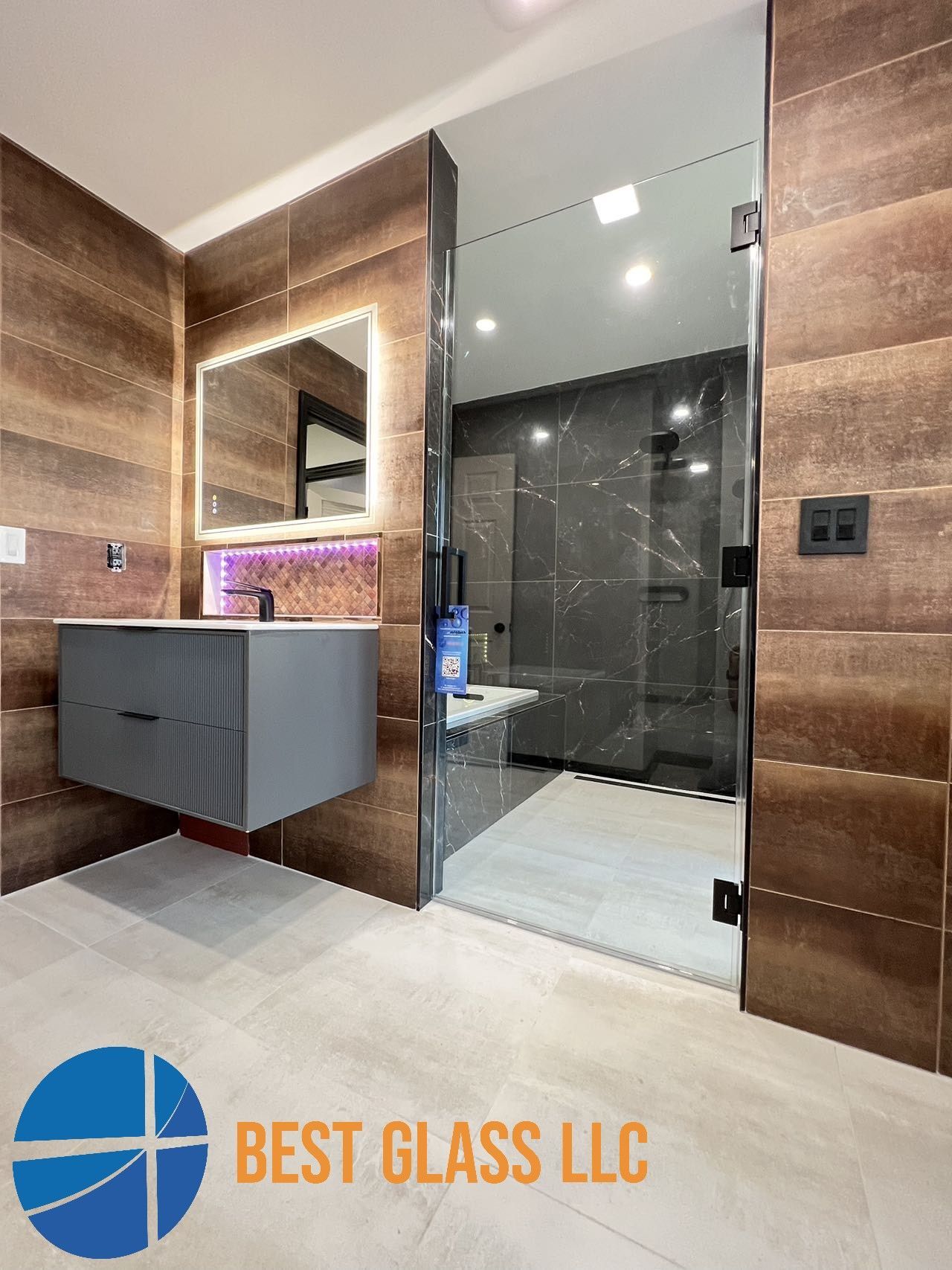 A bathroom with a sink , mirror , and walk in shower.