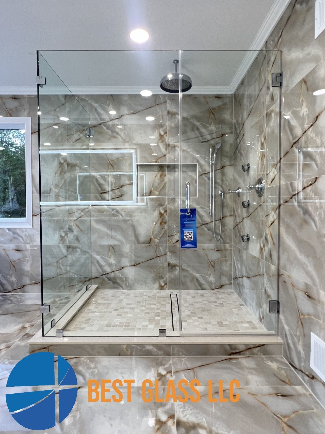 A bathroom with a walk in shower with a glass door.
