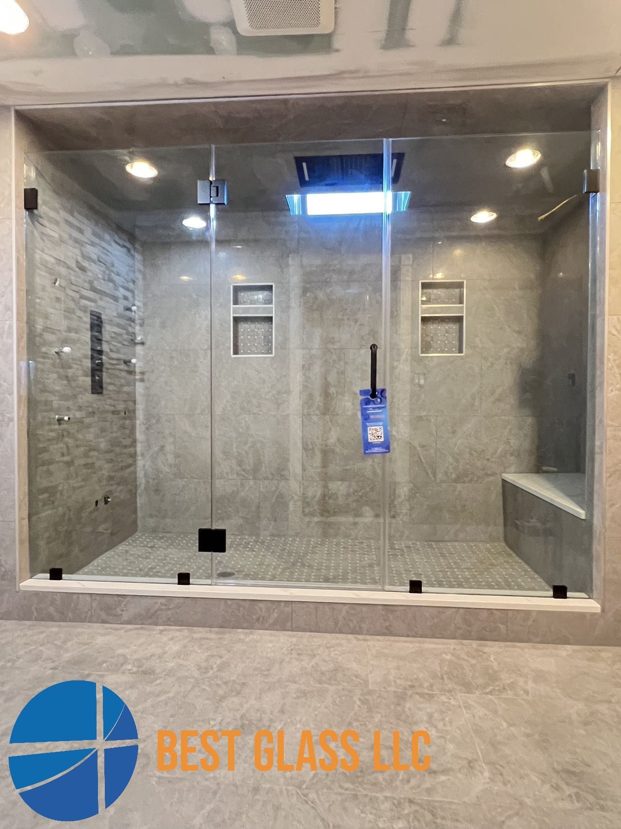 A bathroom with a walk in shower with a glass door.