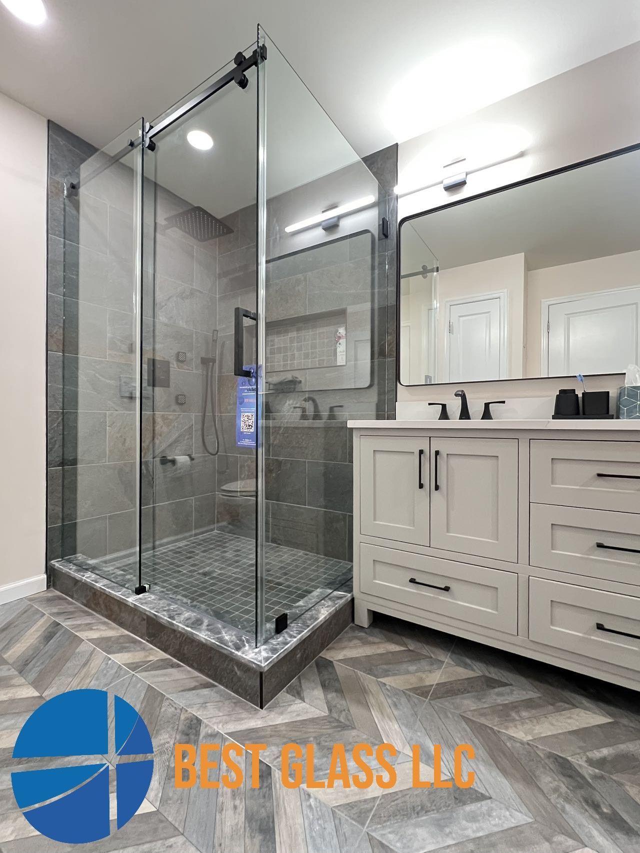 A bathroom with a walk in shower and a sink.