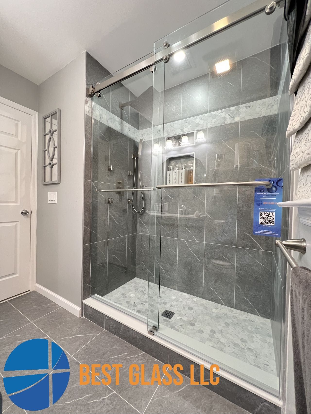 A bathroom with a sliding glass shower door.
