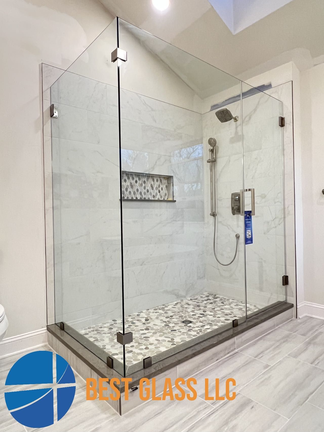 A bathroom with a walk in shower with a glass door.