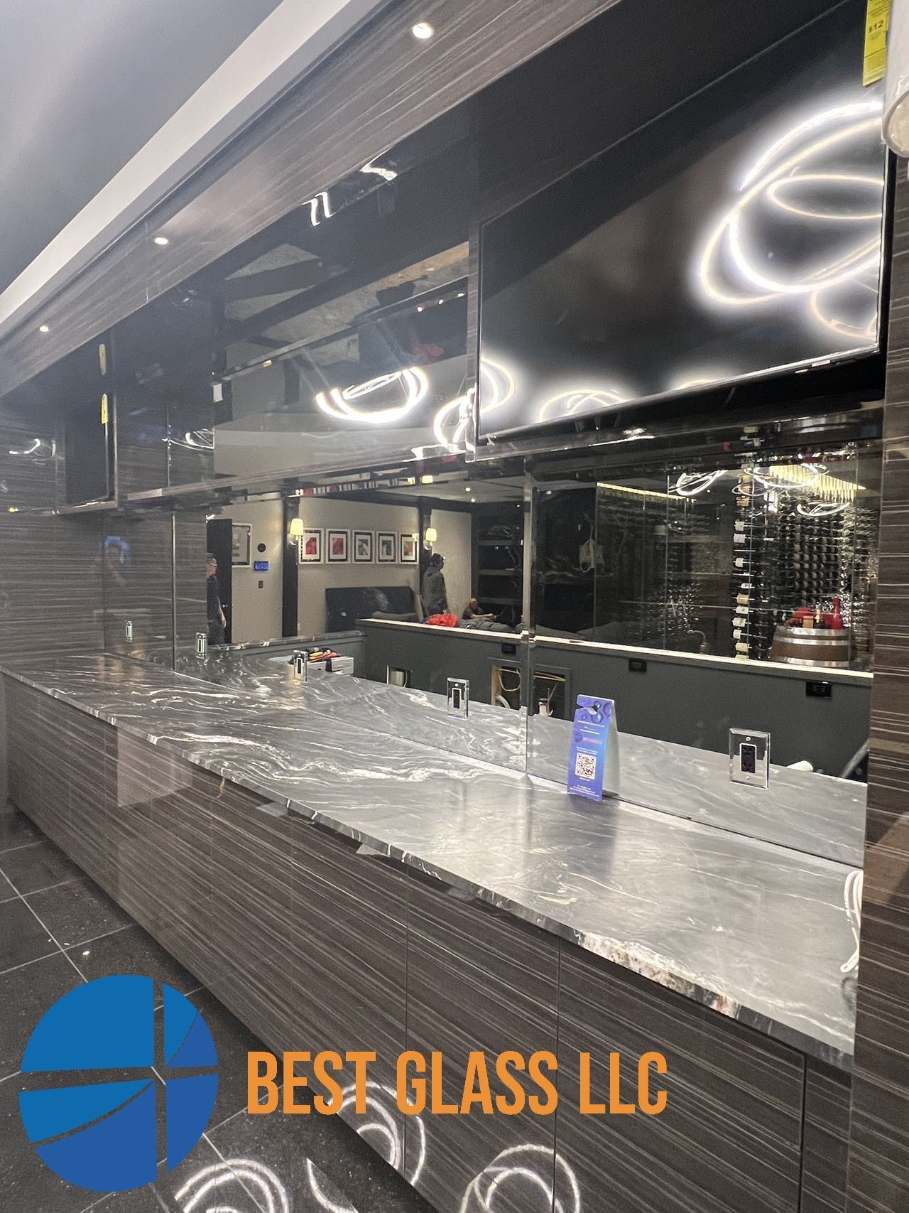 A bar with a lot of mirrors and a sign that says best glass llc