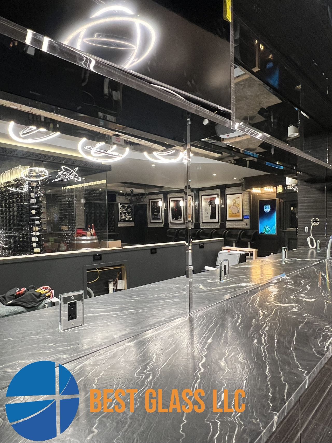 A bar with a marble counter top and a mirrored ceiling.