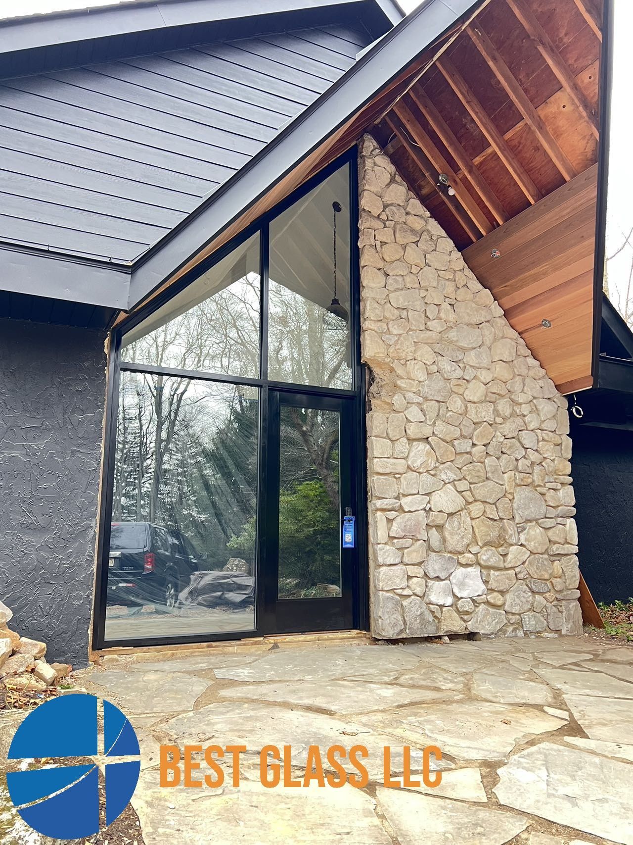A house with a stone wall and a large glass door