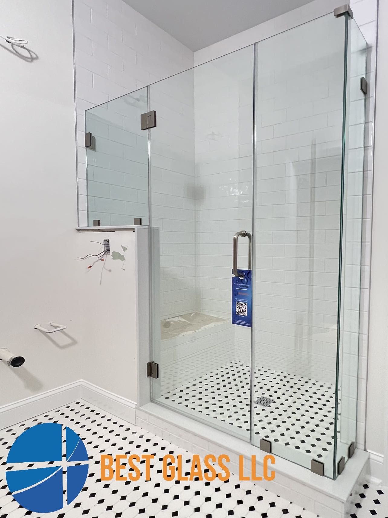 A bathroom with a shower and a sign that says best glass llc